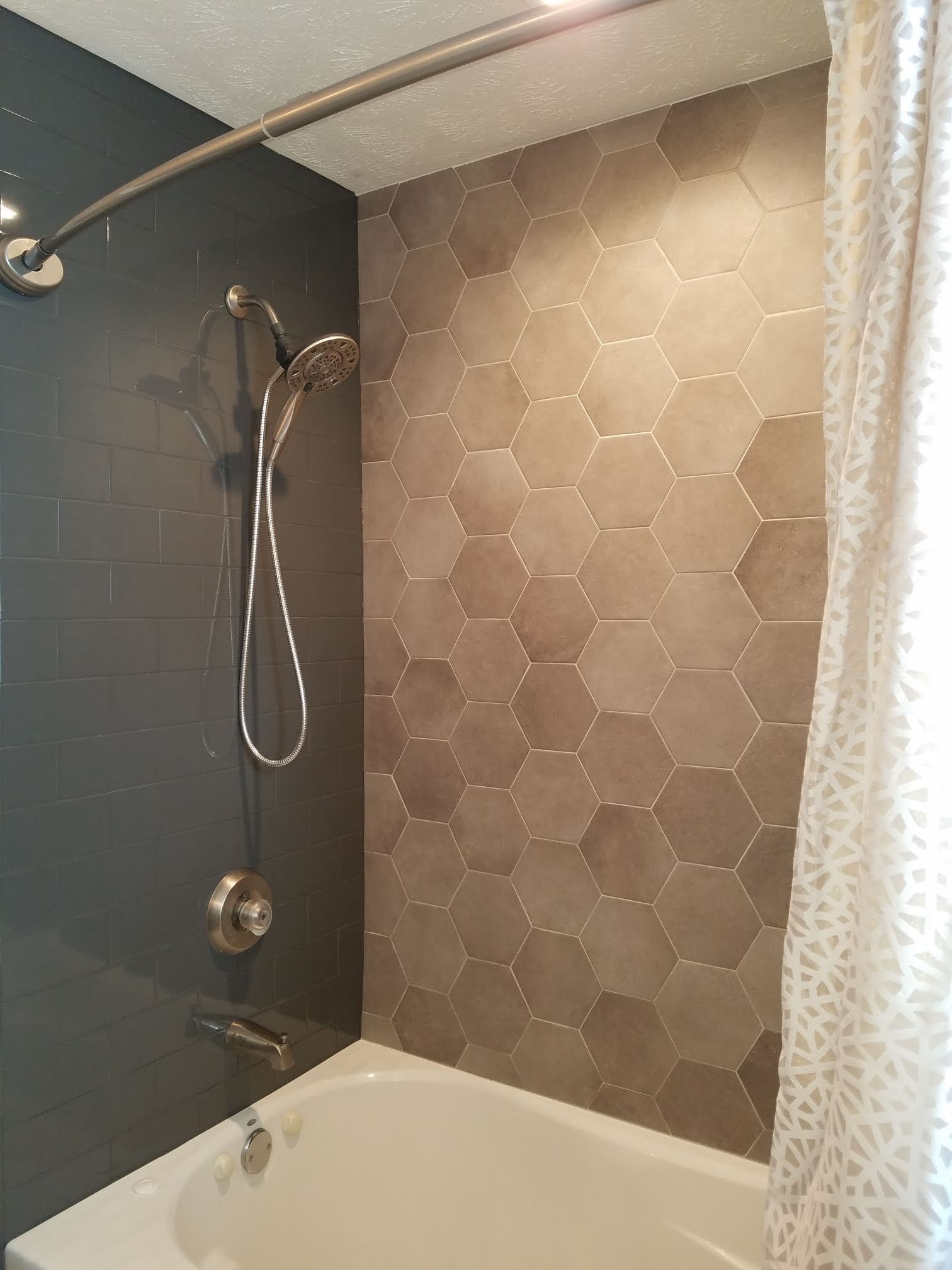 Bathtub shower with black accent wall, hex tile backsplash, and patterned shower curtain