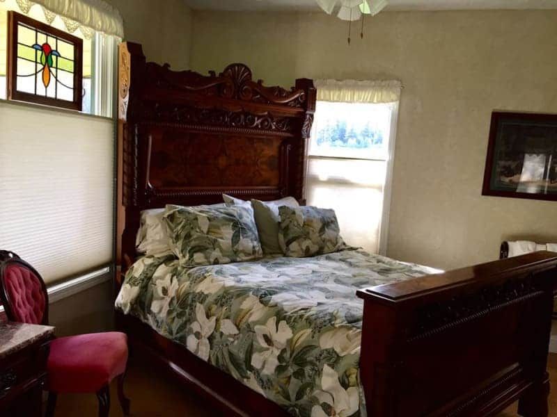 A bedroom with a large bed and a stained glass window