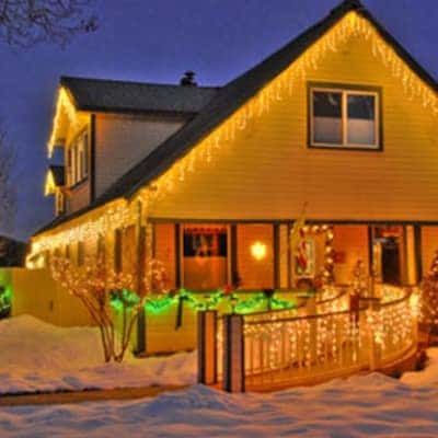 A house is lit up with christmas lights at night.