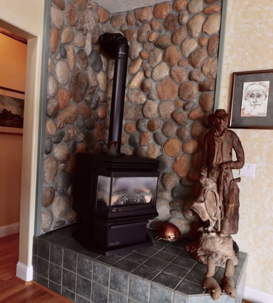 A fireplace with a stone wall and a statue of a man