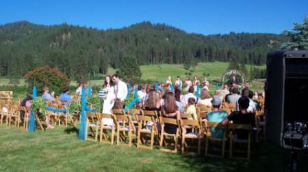 A large group of people are sitting in chairs at a wedding ceremony.