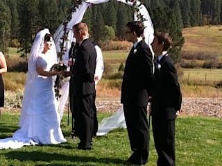 A bride and groom are holding hands during their wedding ceremony.