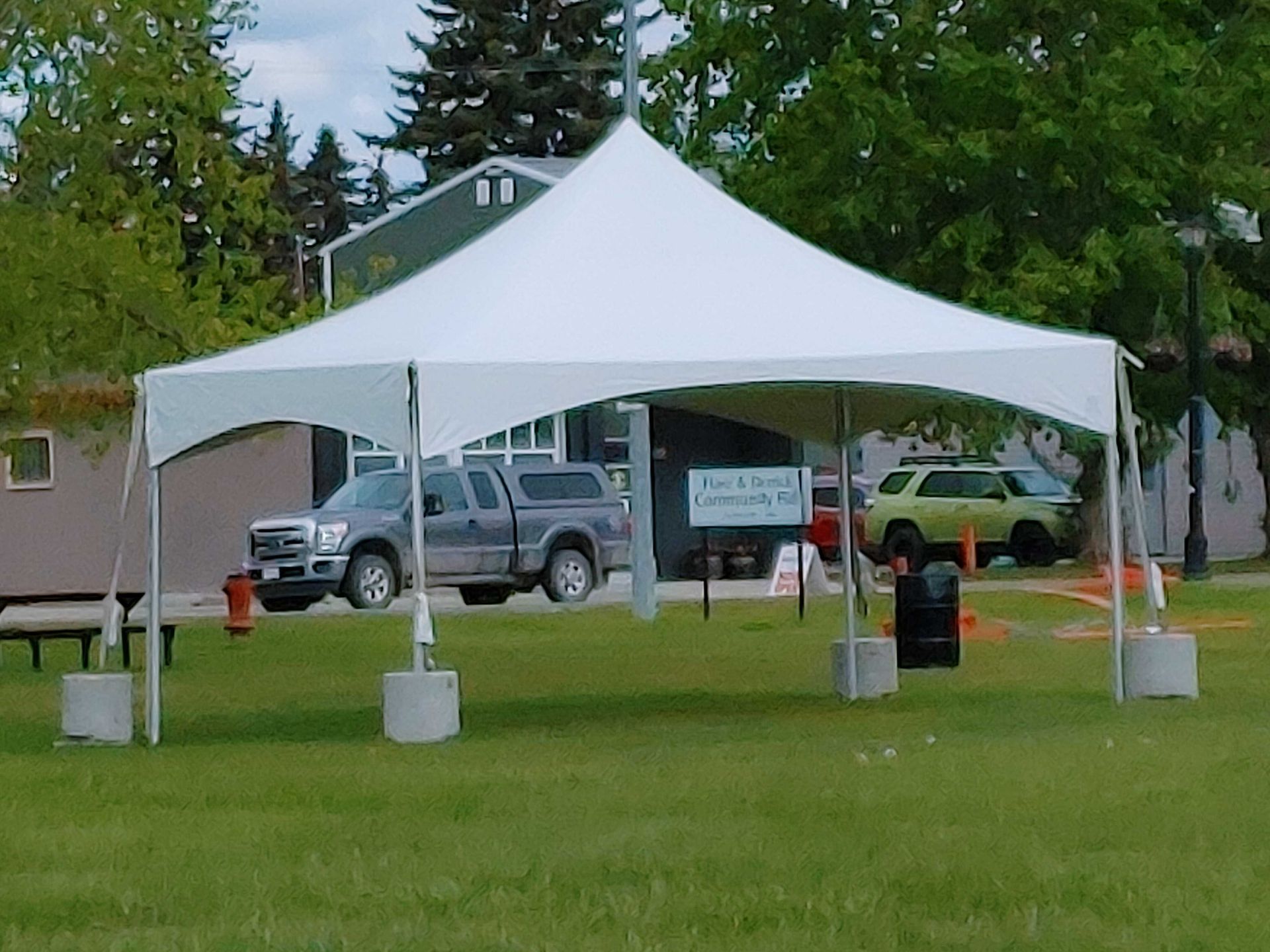 A white tent is sitting in the middle of a grassy field