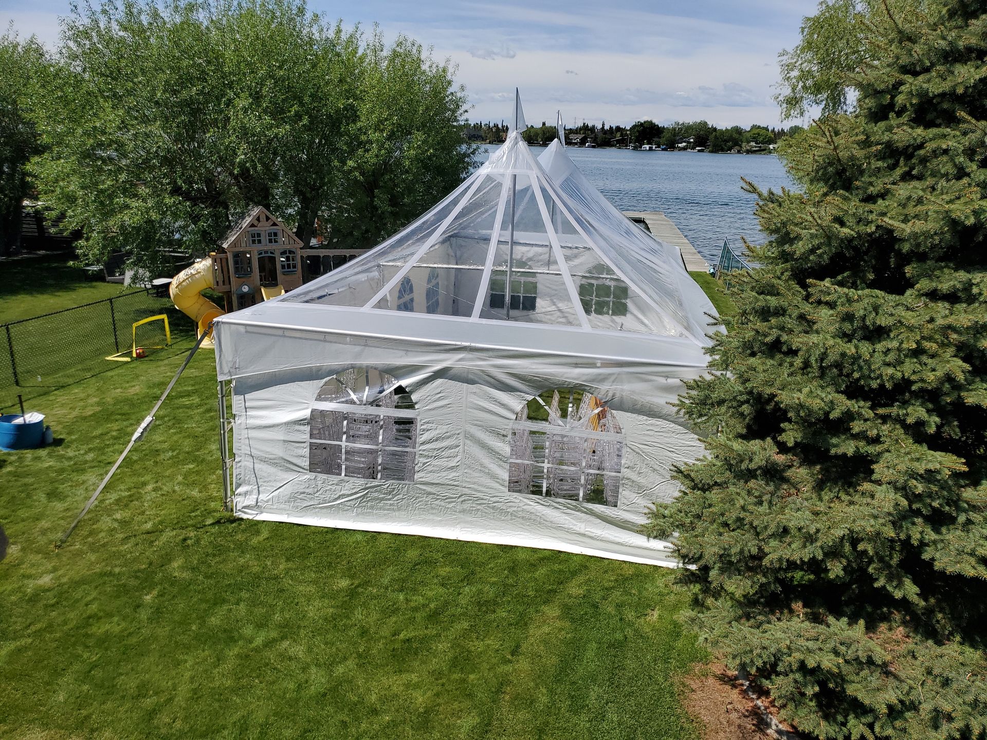 An aerial view of a large white tent in a backyard.