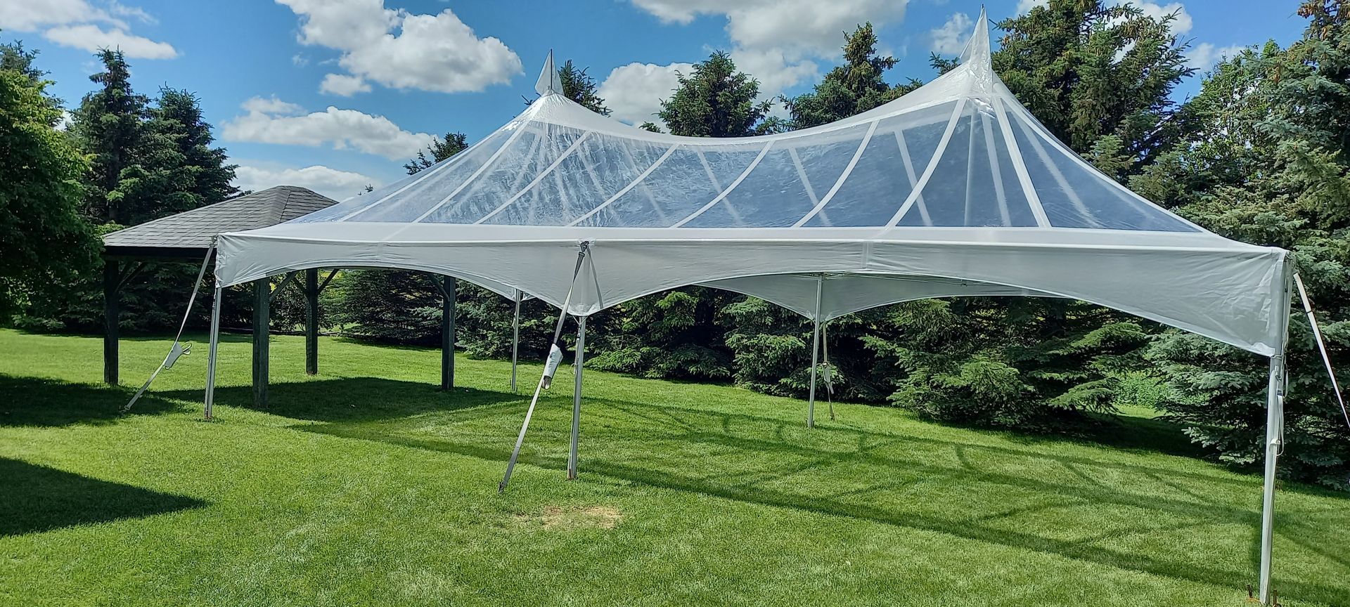 A white tent is sitting on top of a lush green field.