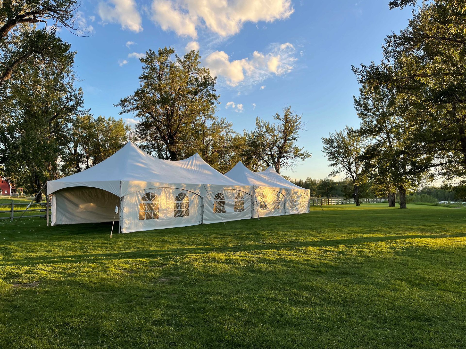 A row of tents are sitting on top of a lush green field.