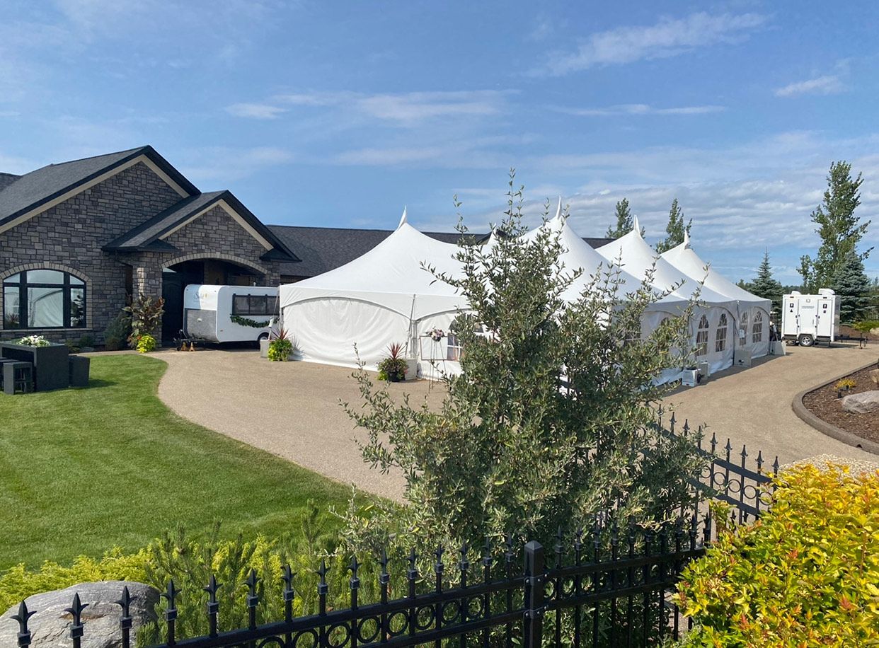 A large house with a lot of tents in front of it.
