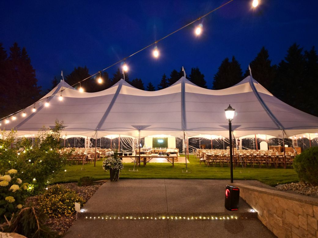 A large white tent is lit up at night