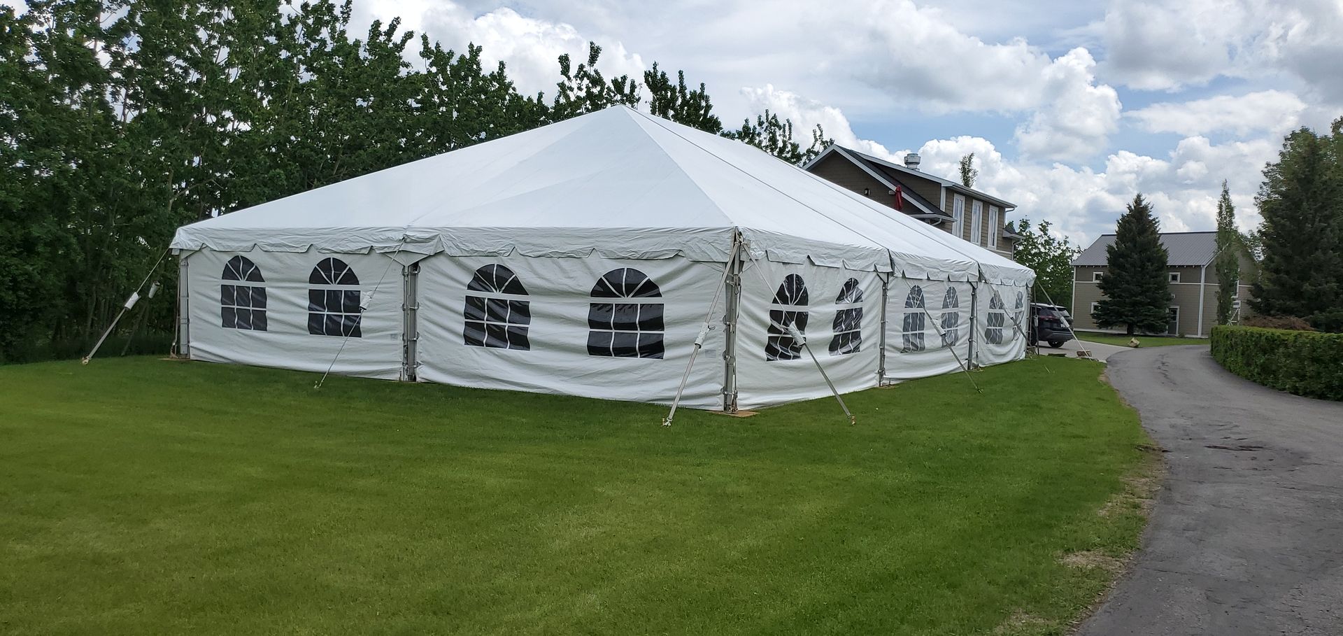 A large white tent is sitting in the middle of a grassy field.