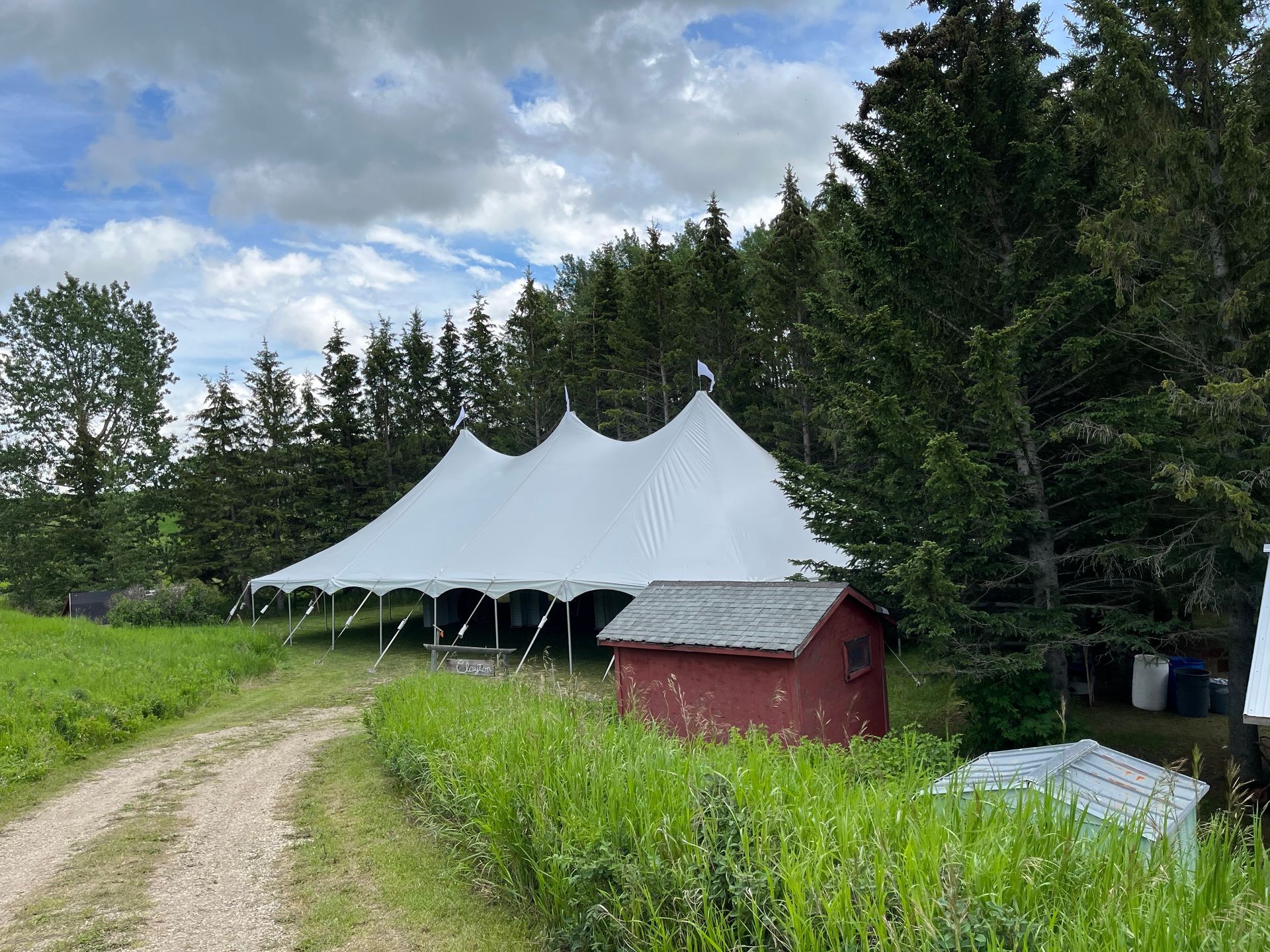A large white tent is sitting in the middle of a grassy field.