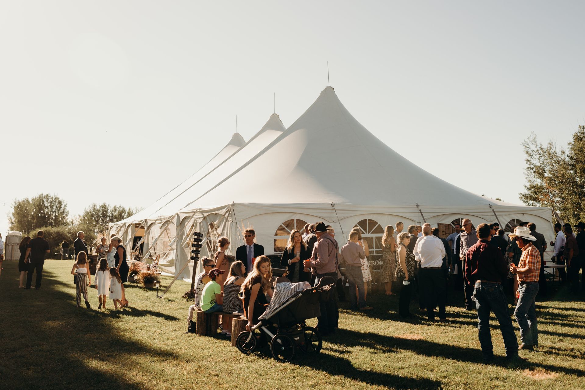 A group of people are standing in front of a large tent.