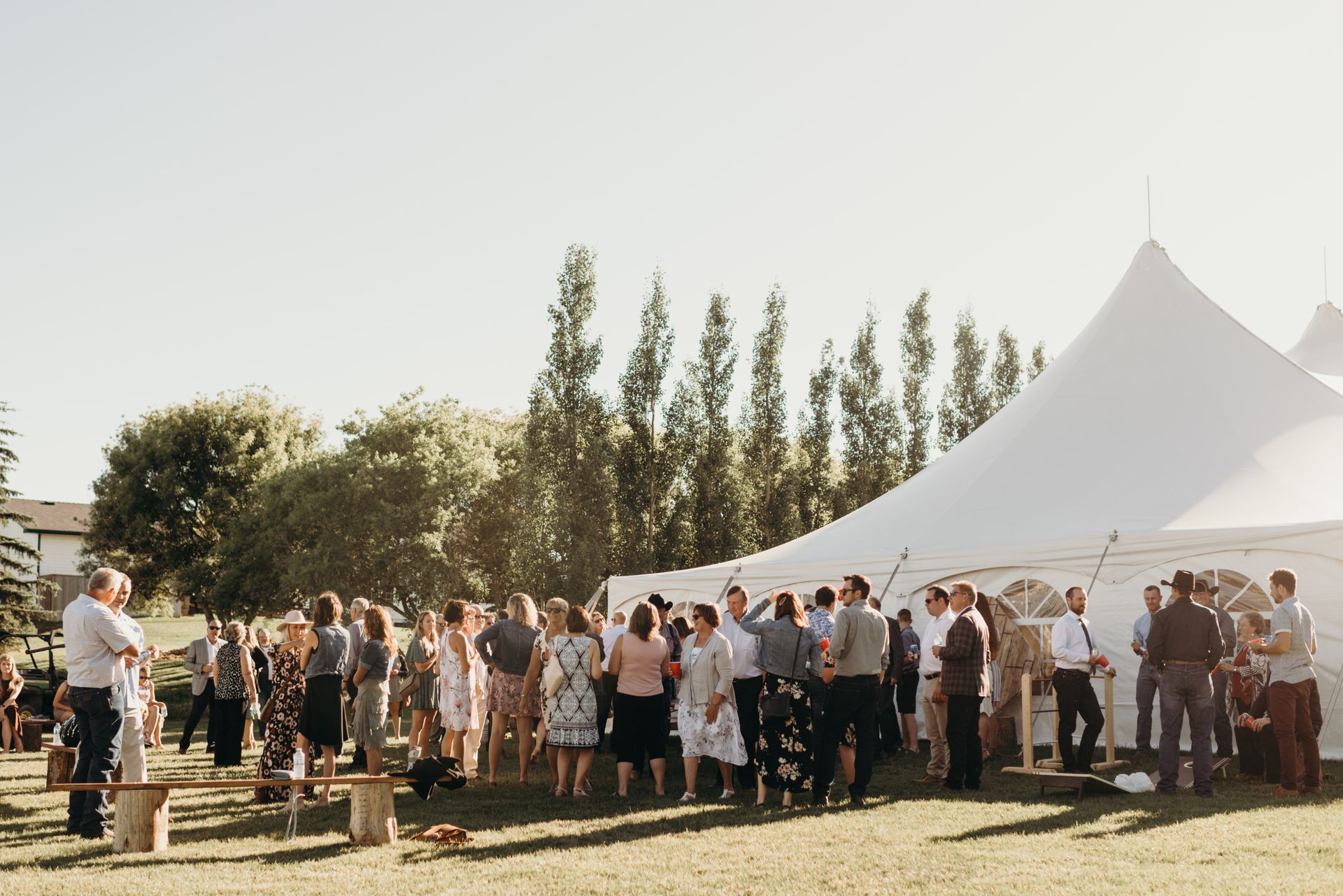 A large group of people are standing outside of a tent.