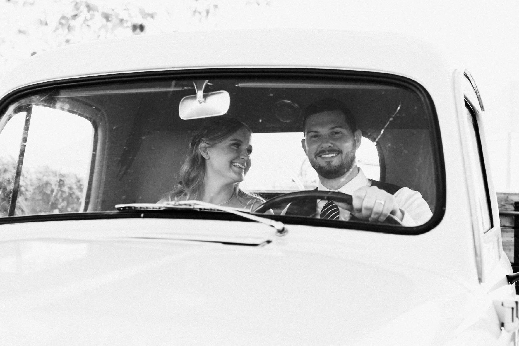 A man and a woman are sitting in the back of a truck.