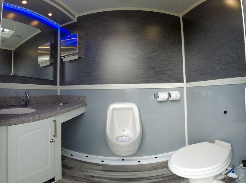 A bathroom with a toilet , urinal and sink