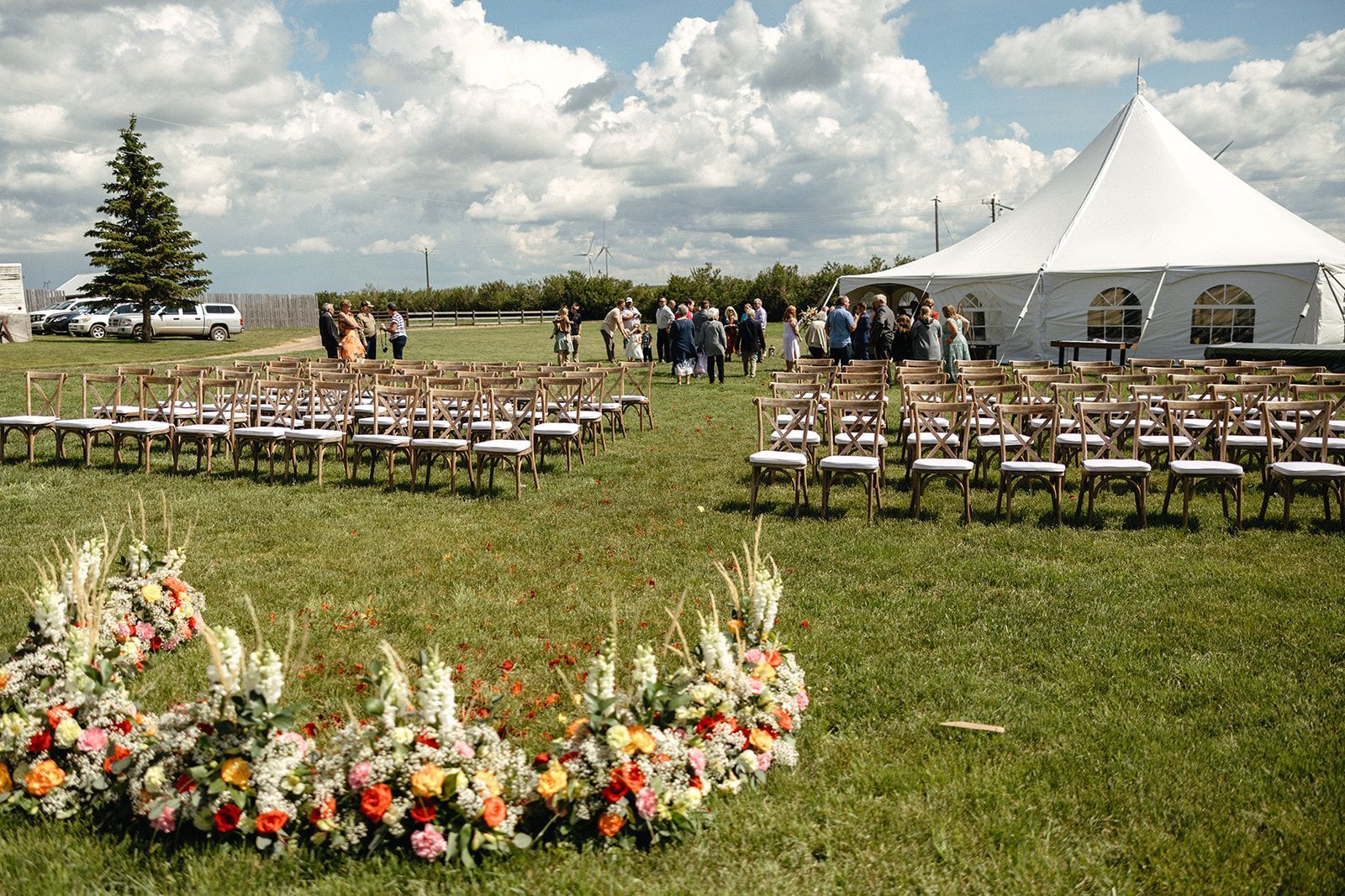 A large white tent is sitting in the middle of a grassy field.