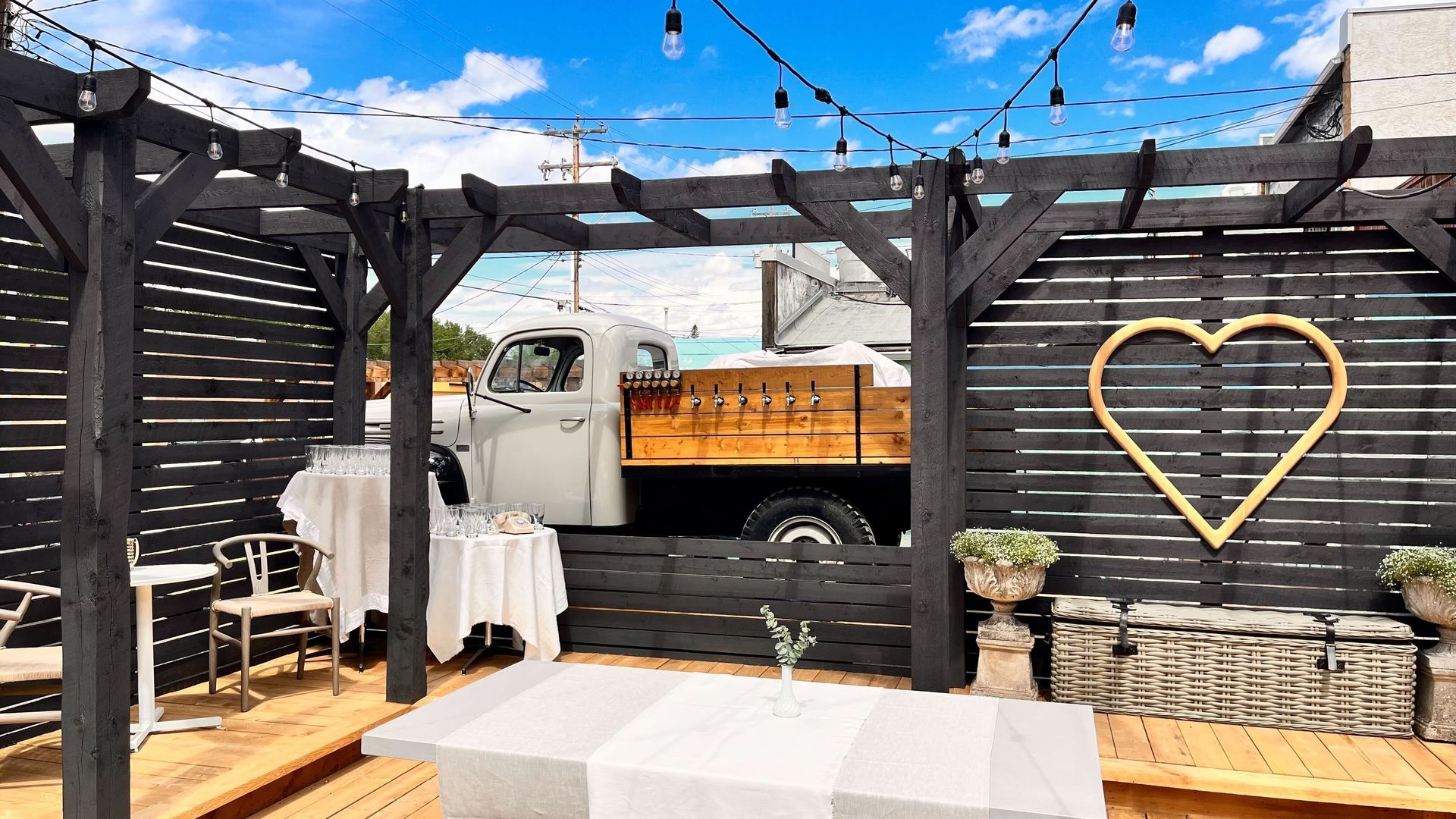 A truck is parked under a pergola with a heart on it.