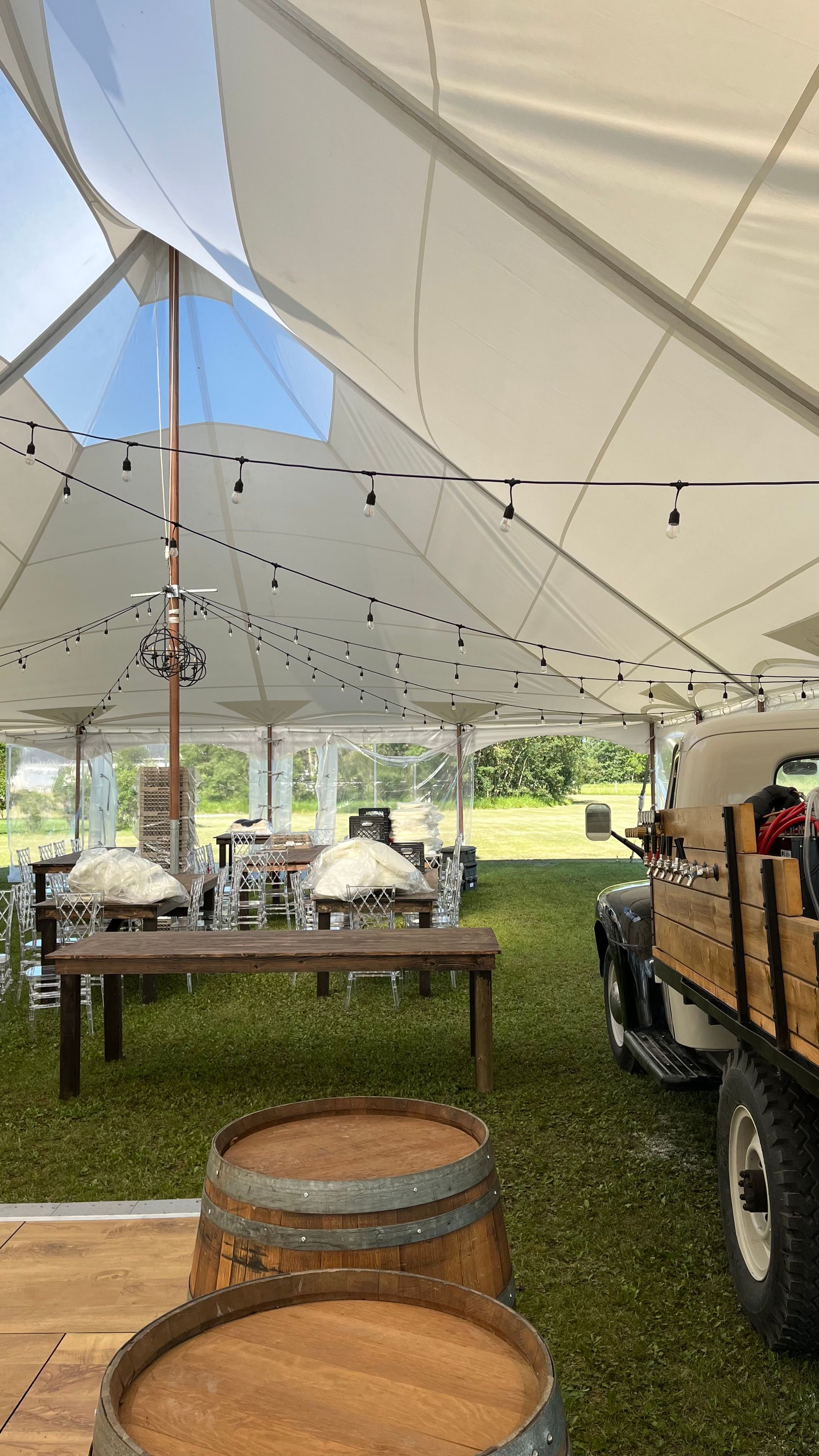 Two wooden barrels are sitting under a tent.