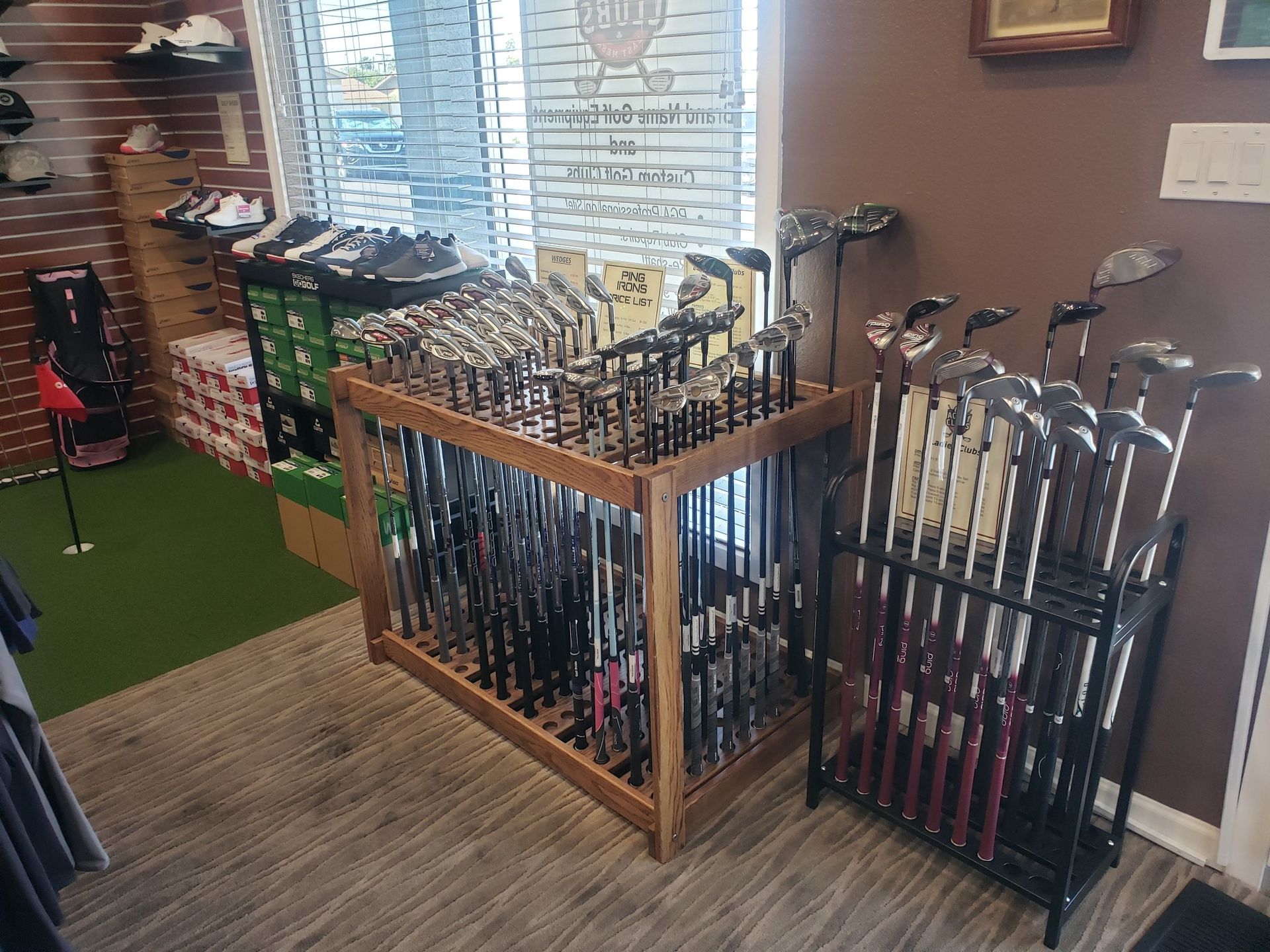 A bunch of golf clubs are sitting on a rack in a store.