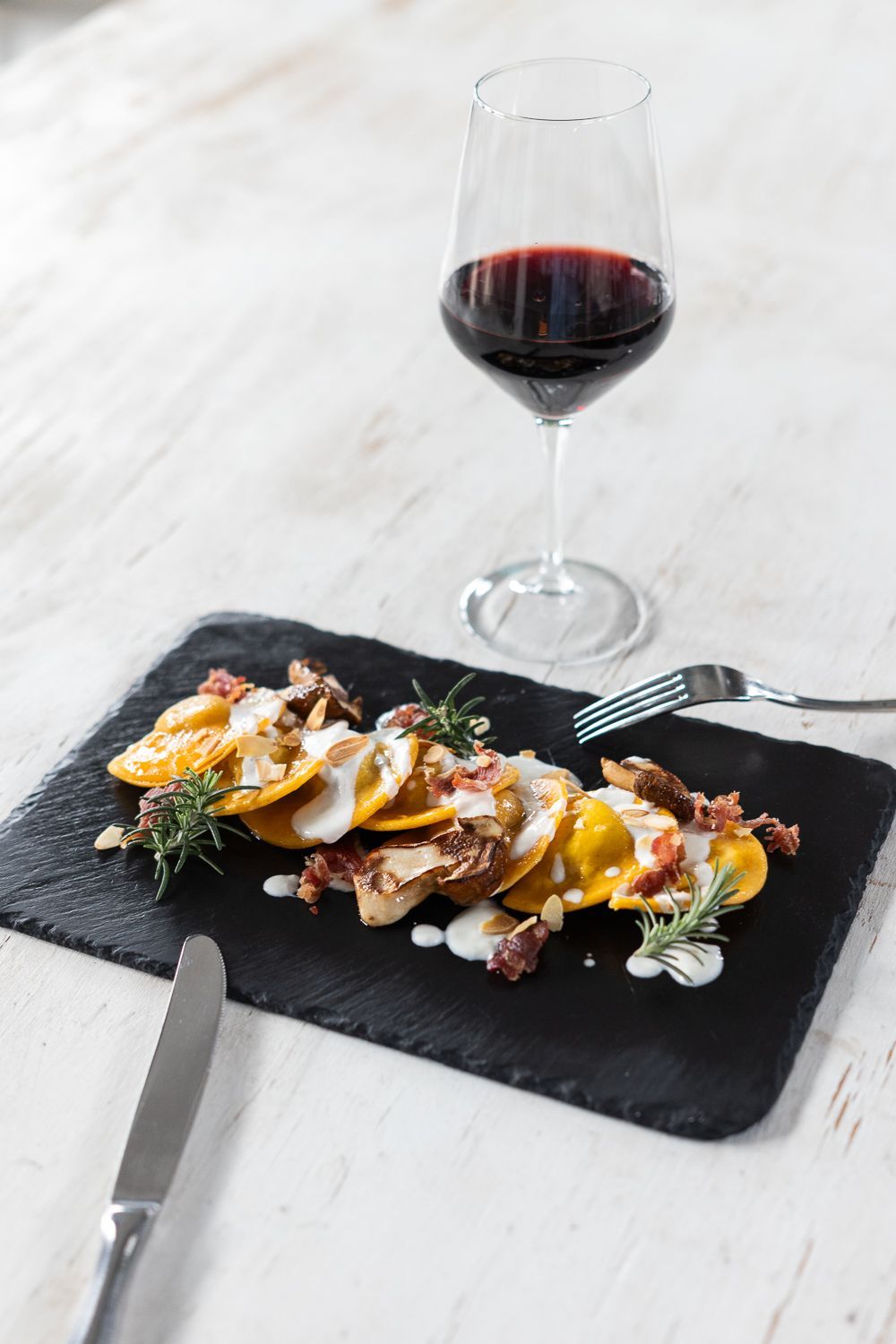 Un piatto di cibo e un bicchiere di vino su un tavolo.