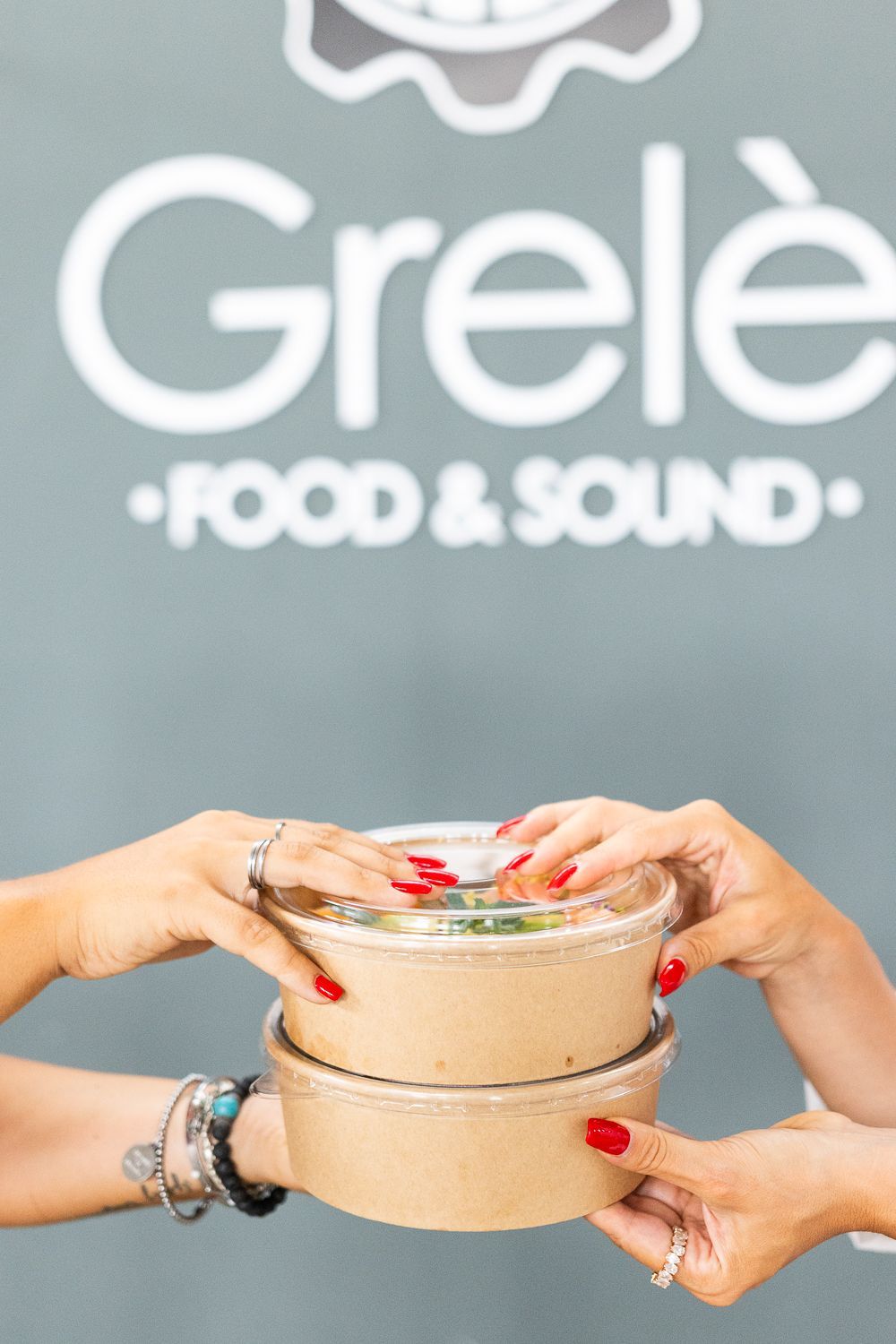 Due donne che tengono ciotole di cibo davanti a un segnale di cibo e suono grele