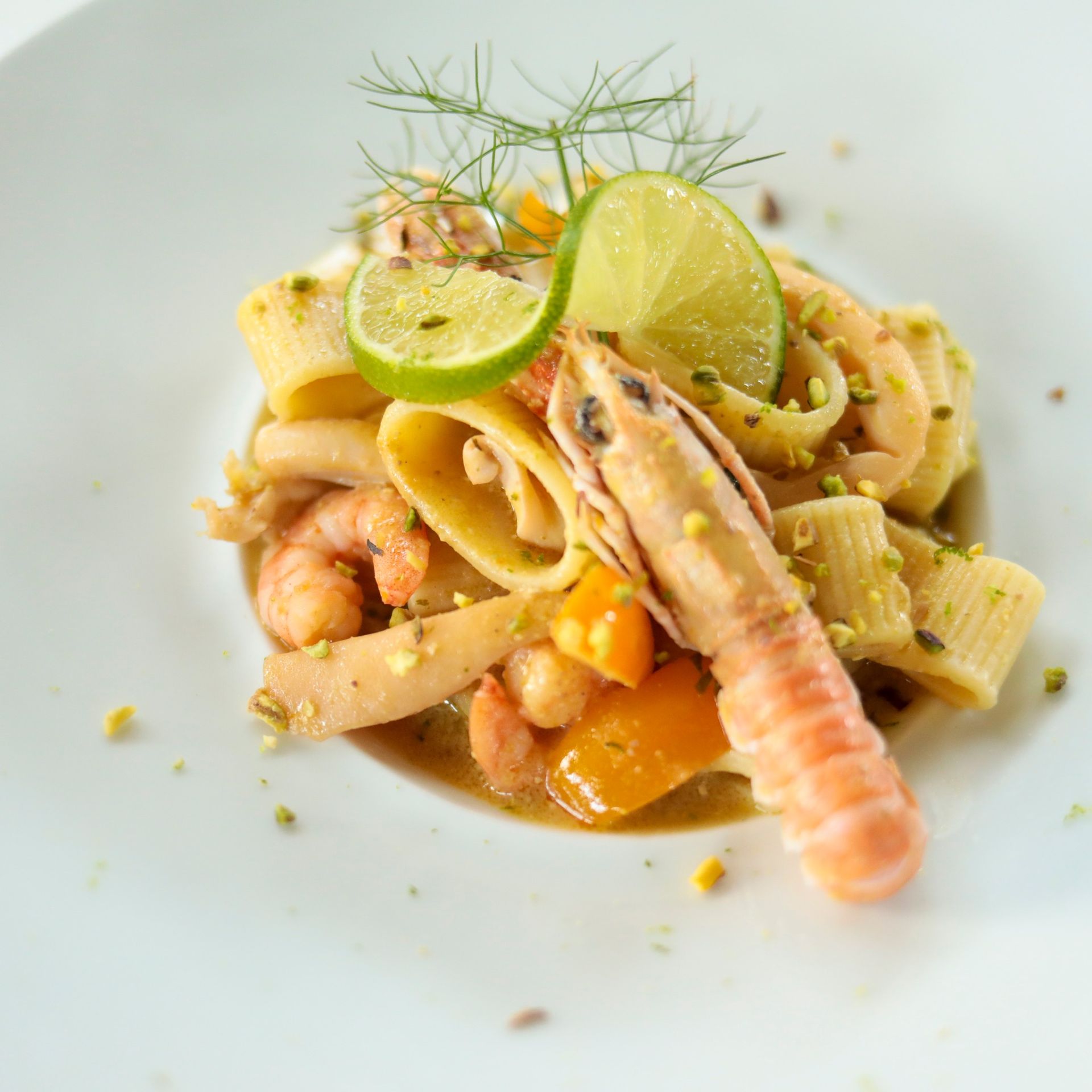 Un primo piano di un piatto di cibo con gamberi e tagliatelle