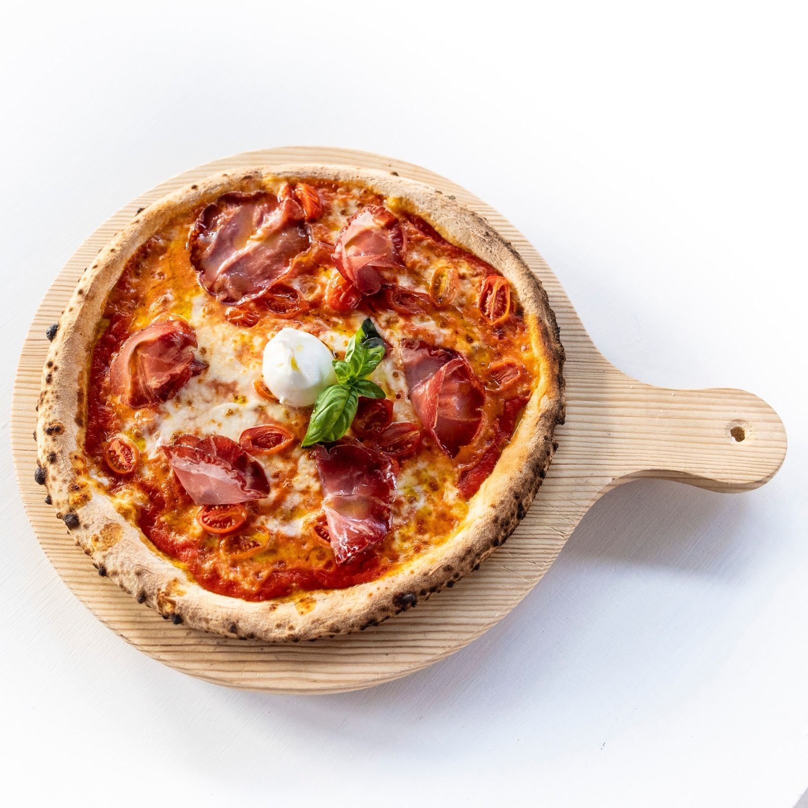 Una pizza è appoggiata su un tagliere di legno.