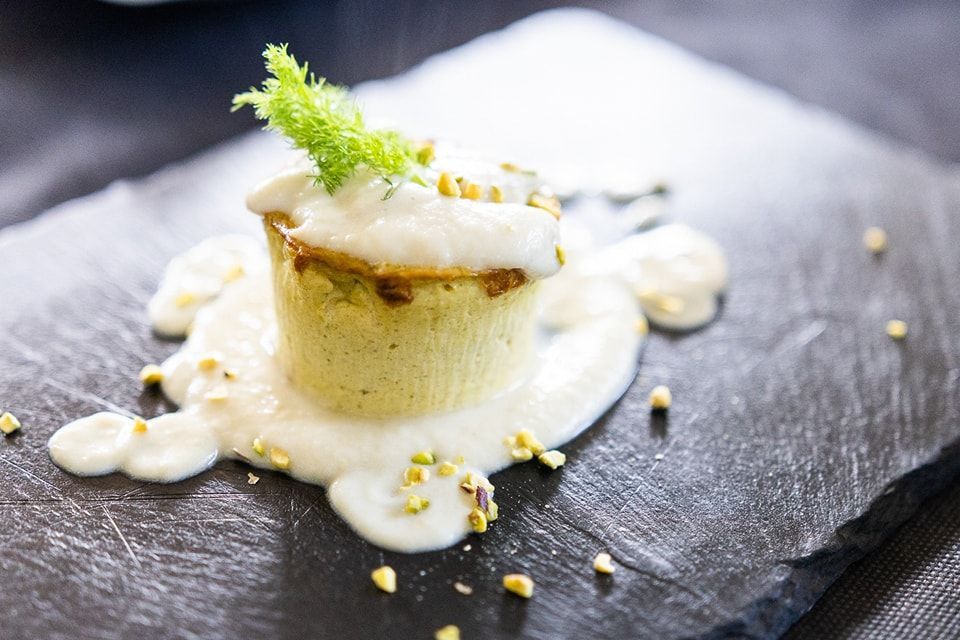 Un primo piano di un dessert su un piatto di ardesia su un tavolo.