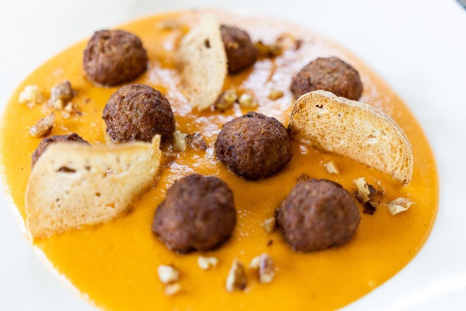Primo piano di una ciotola di zuppa con polpette e cracker.