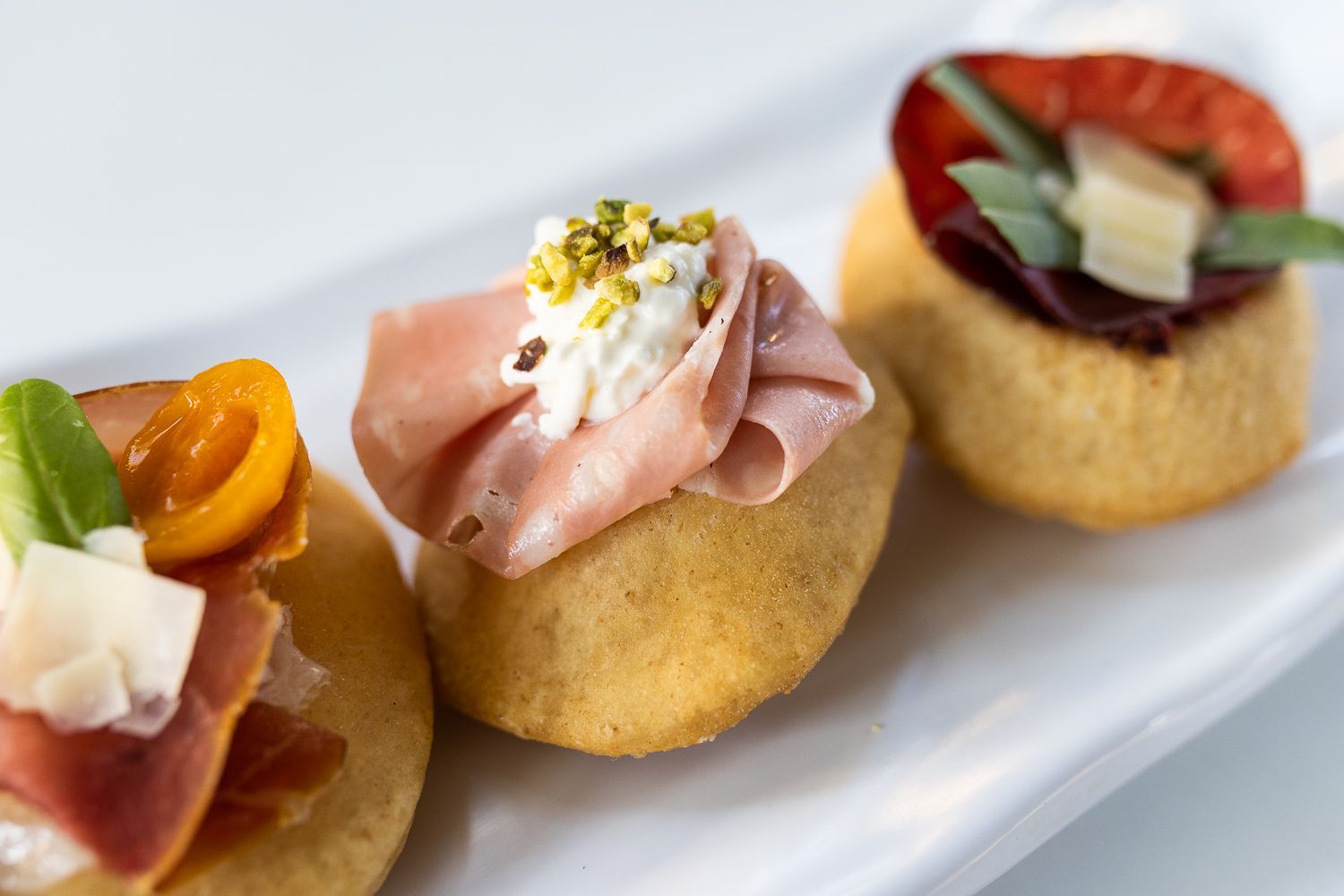 Un piatto bianco sormontato da tre diversi tipi di cibo.