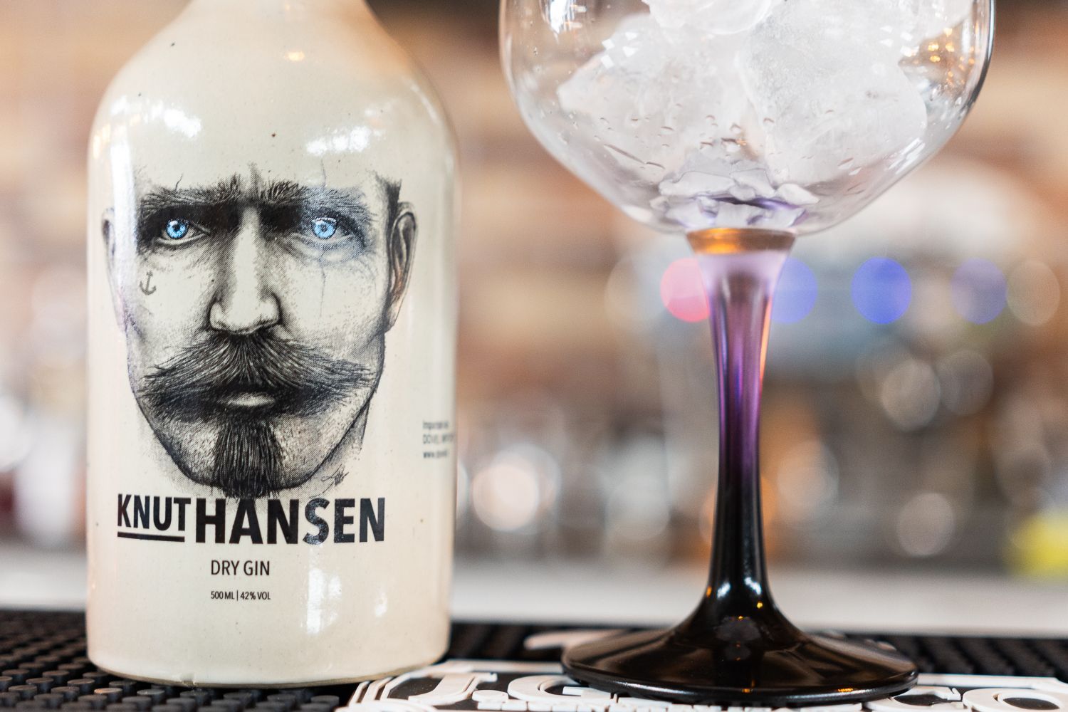 Una bottiglia di knuthansen accanto a un bicchiere di ghiaccio