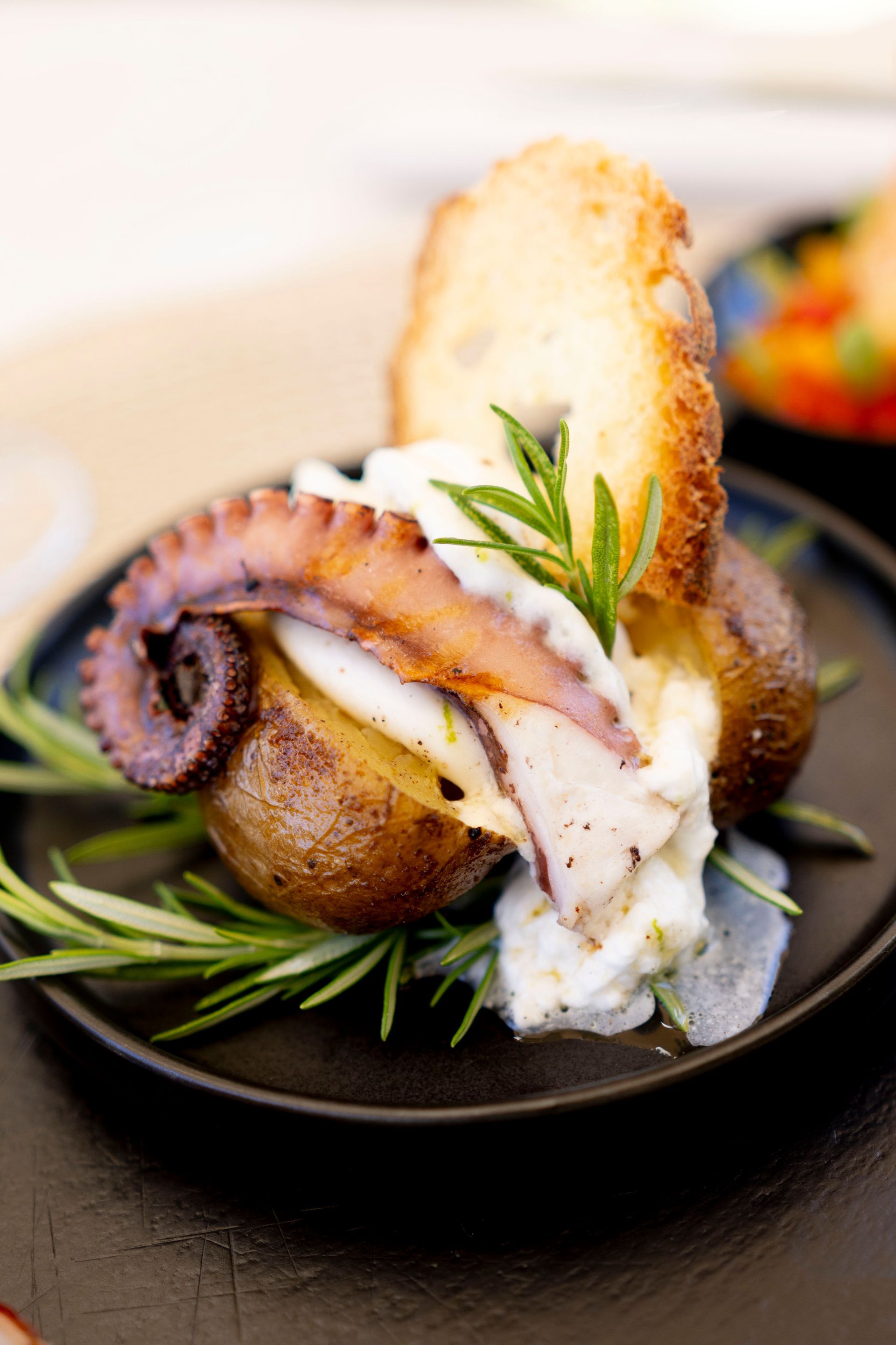 Un primo piano di un piatto di cibo con un polpo e delle patate su un tavolo.