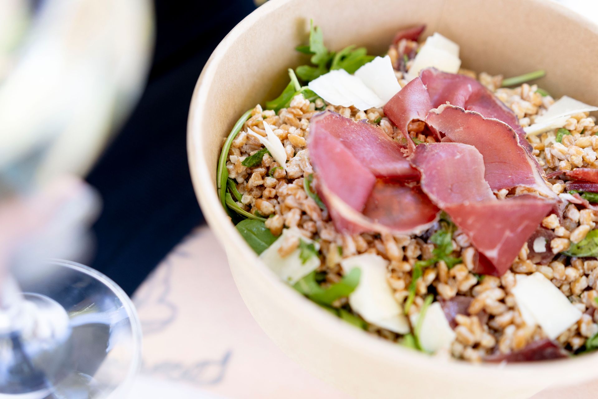 Un primo piano di una ciotola di cibo con carne e riso su un tavolo.