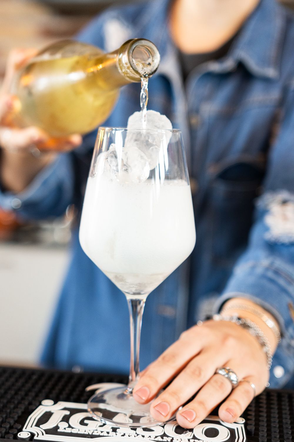 Una donna sta versando un drink in un bicchiere di vino.