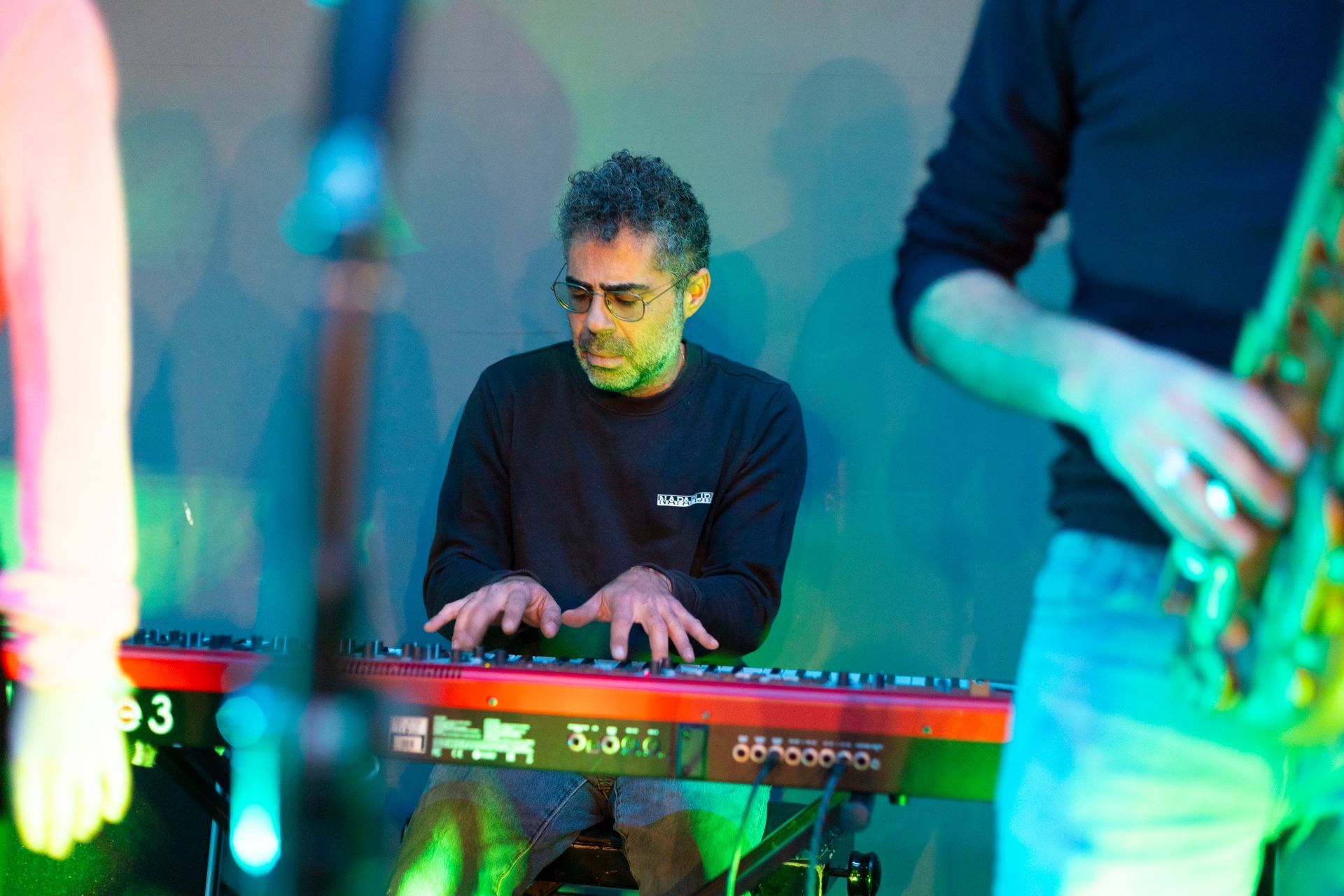 Un uomo suona una tastiera su un palco mentre un altro uomo suona la chitarra.