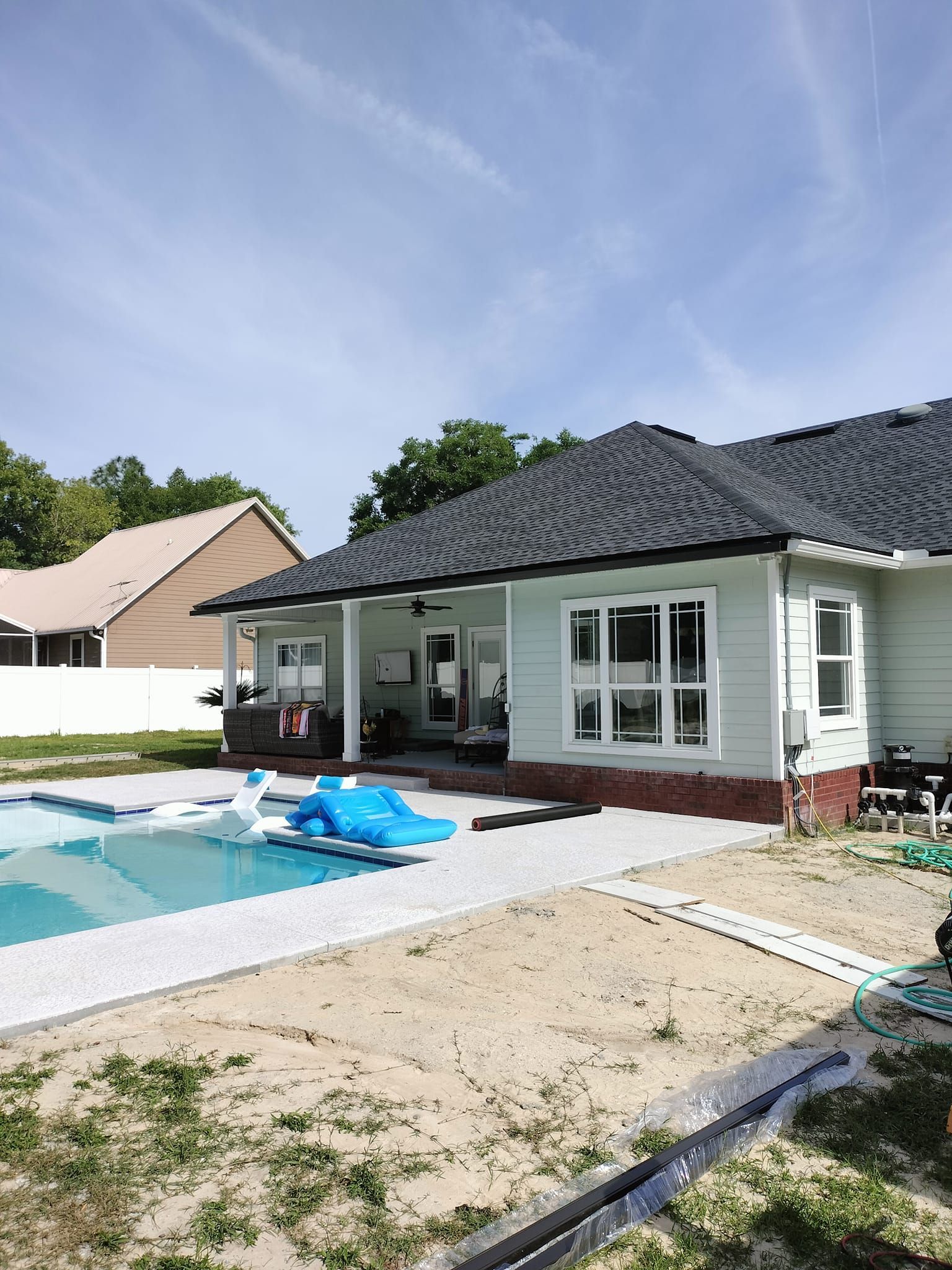 A white house with a swimming pool in the backyard.