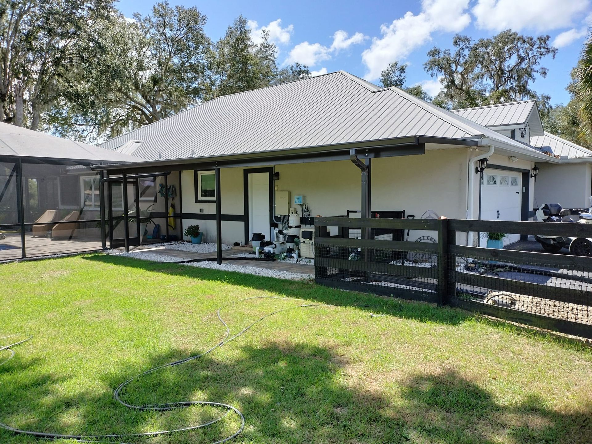 A white house with a black fence in front of it.
