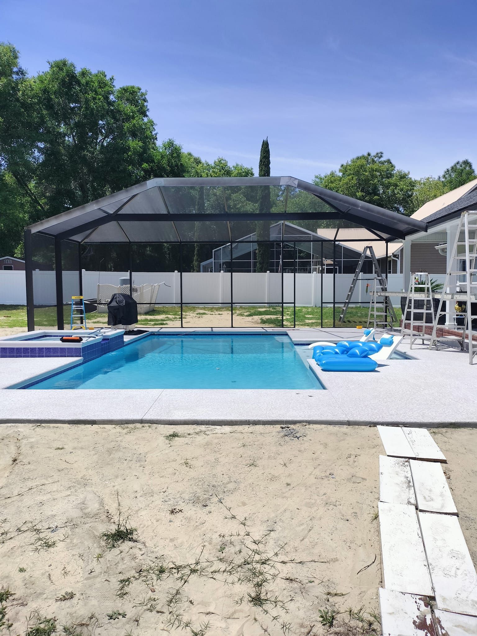 There is a large swimming pool in the backyard of a house.