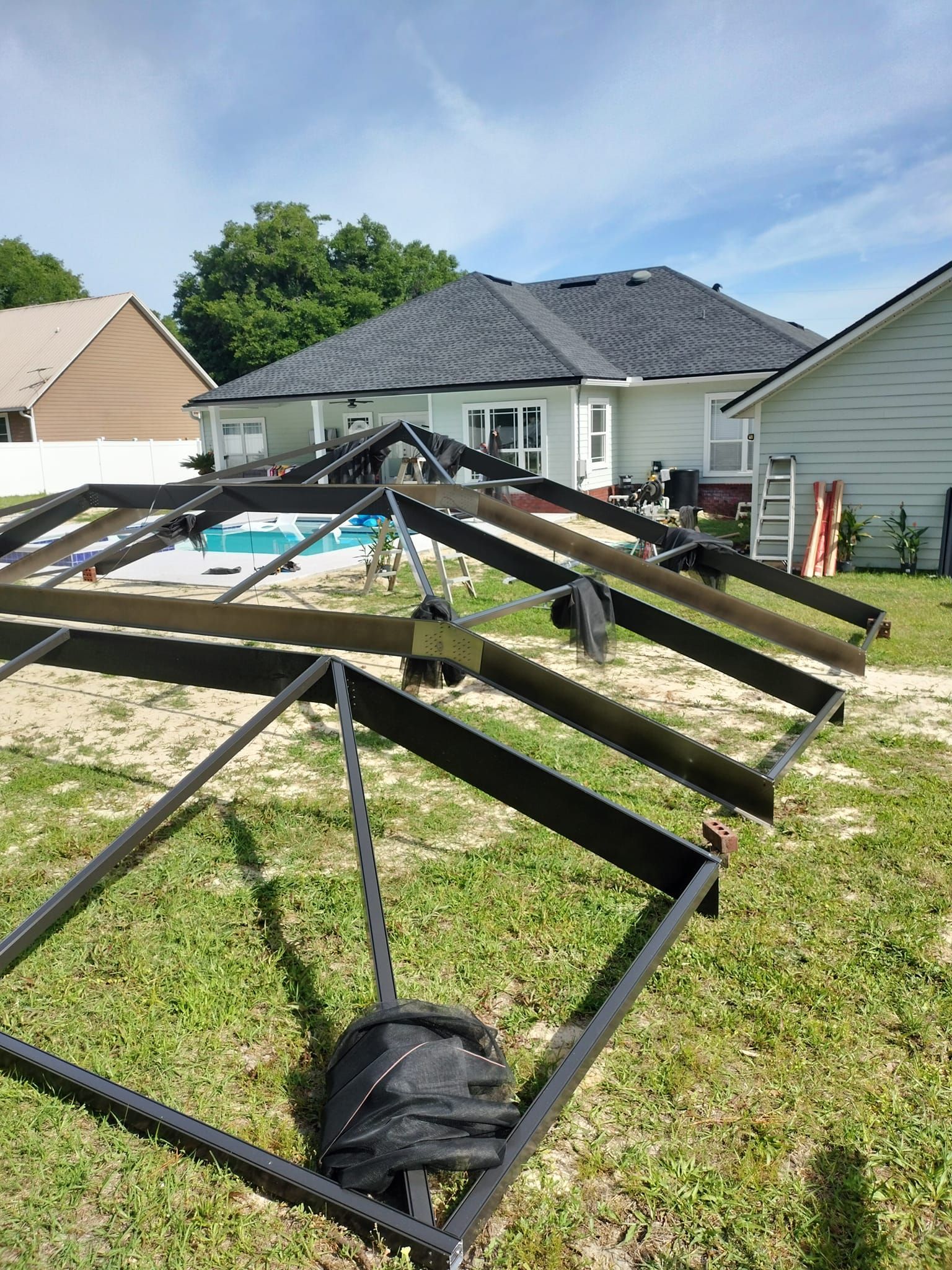 A trailer is sitting on top of a lush green field in front of a house.