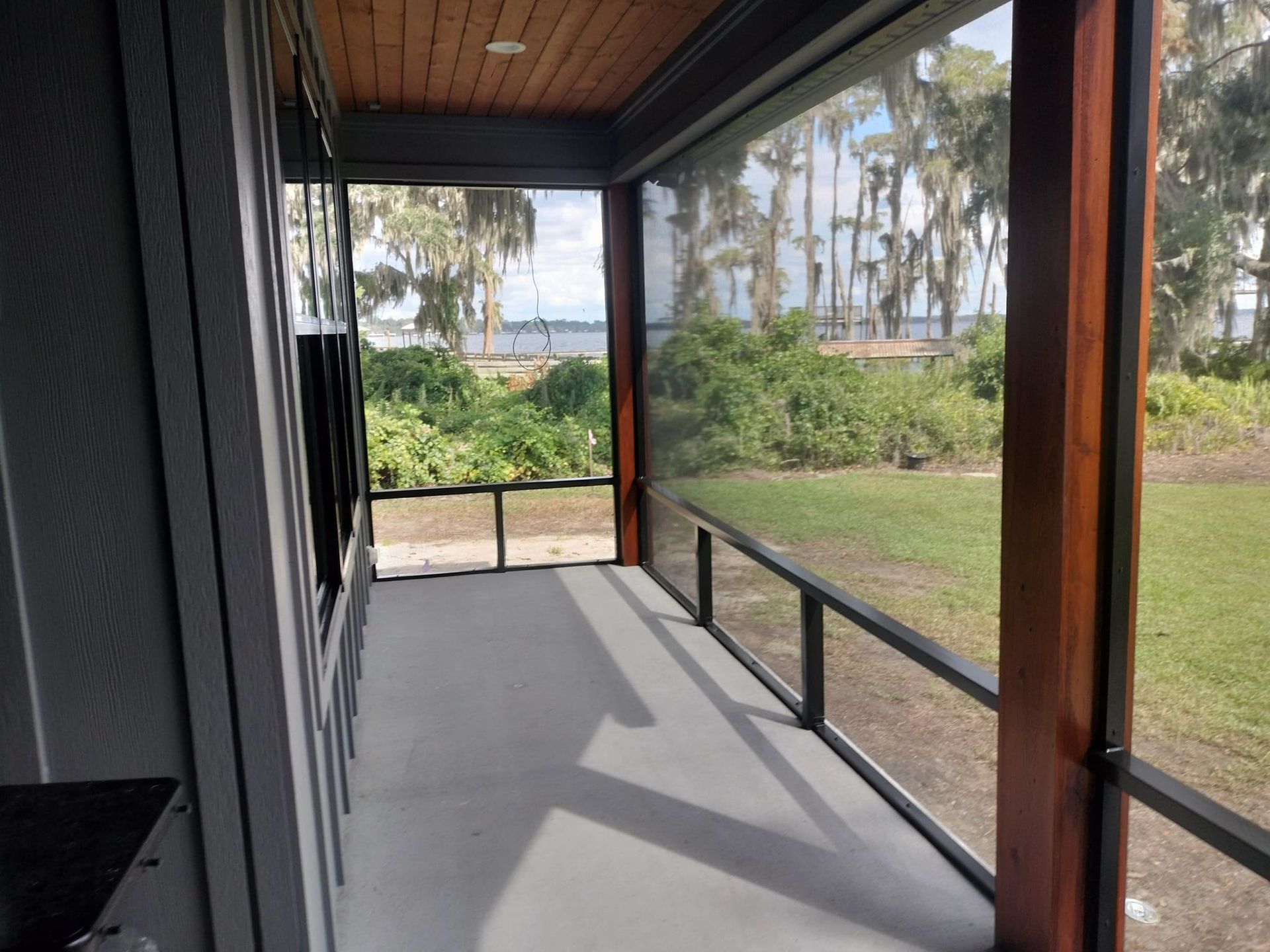 A screened in porch with a view of the ocean