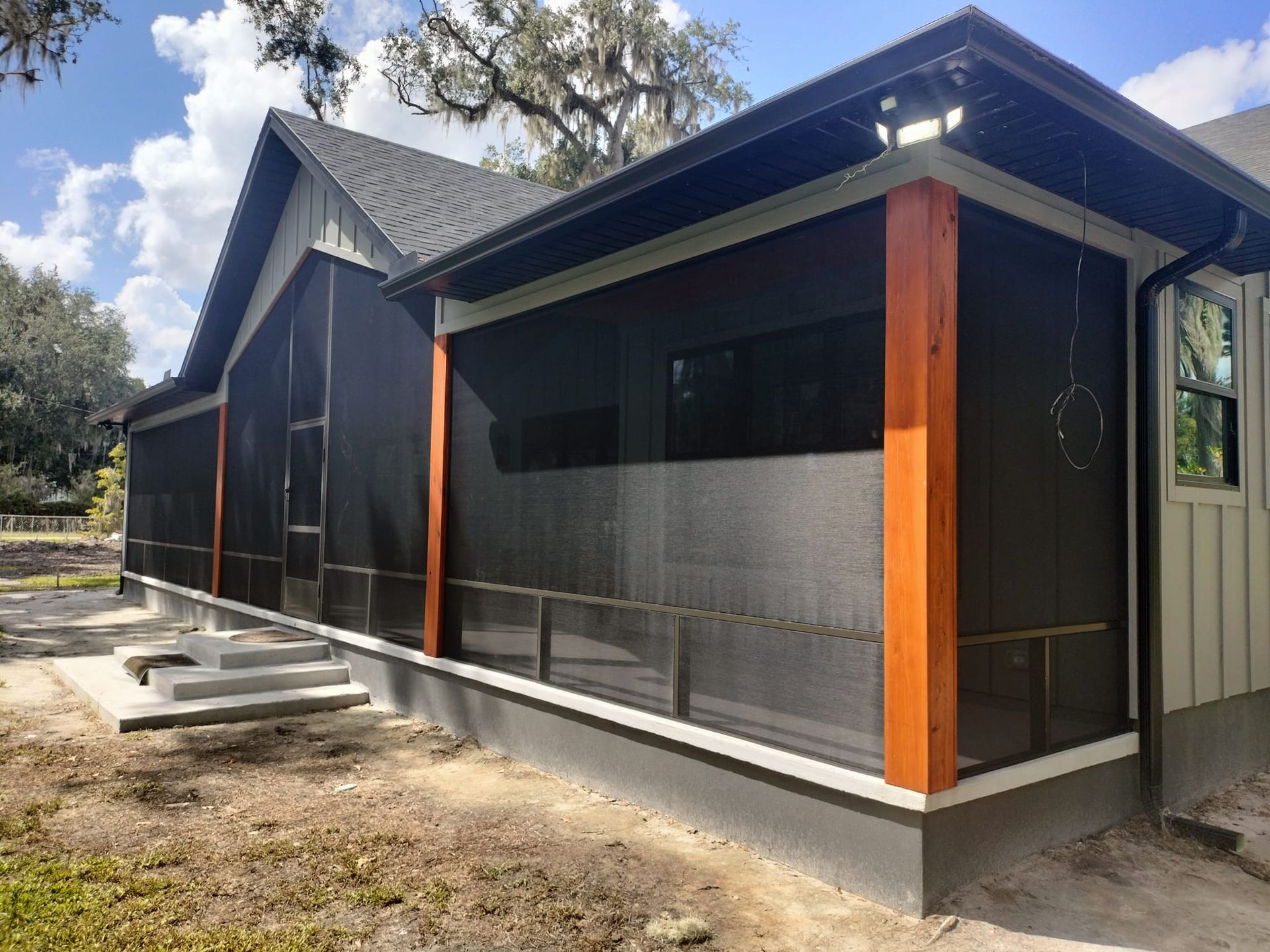 A screened in porch on the side of a house
