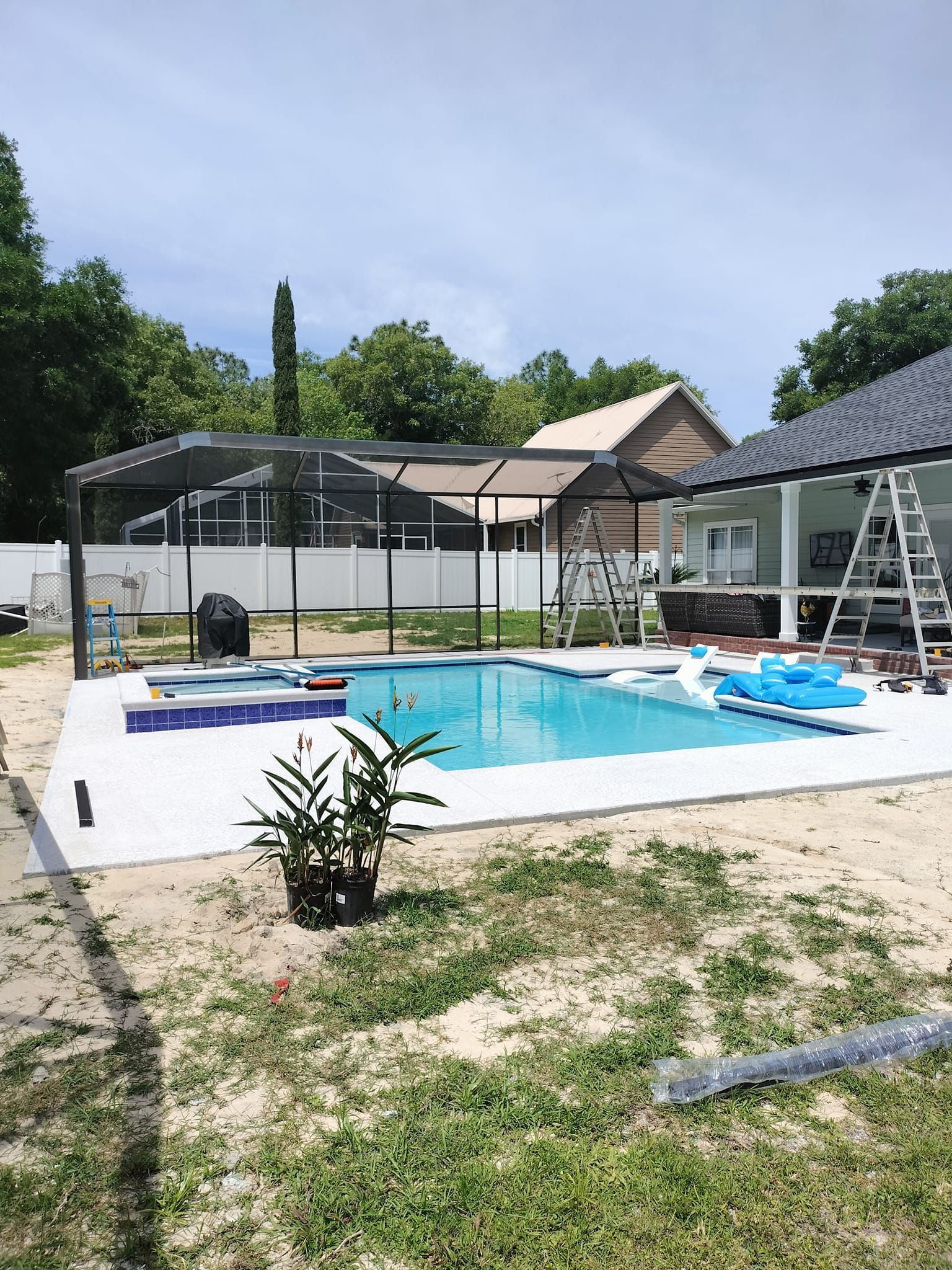 A large swimming pool is being built in the backyard of a house.