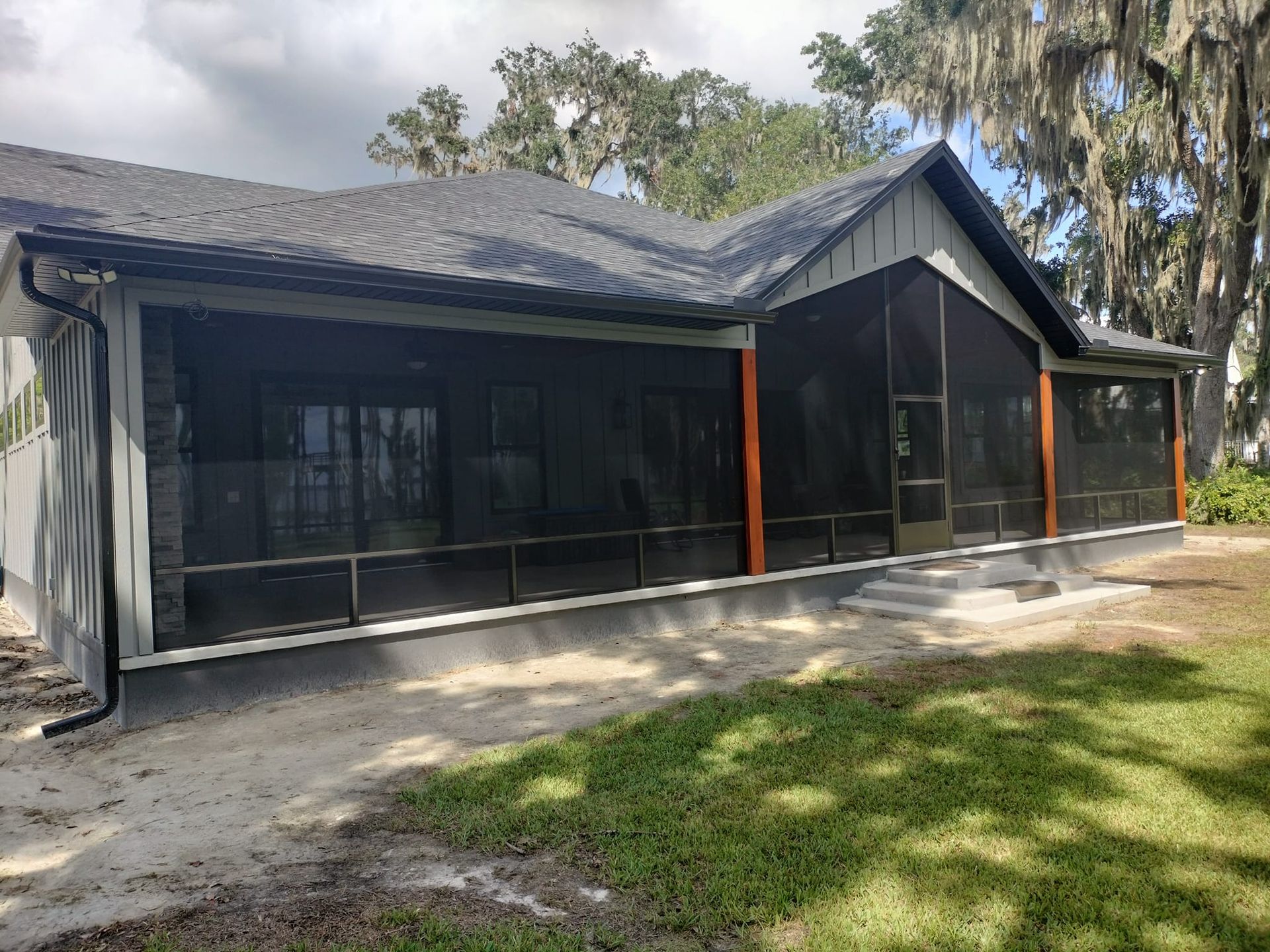 A house with a screened in porch in the backyard.