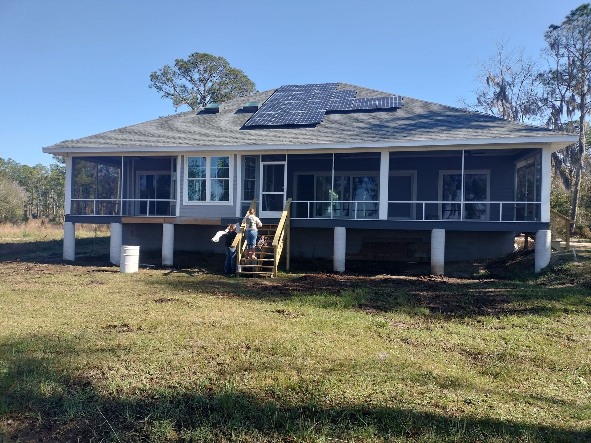 A large house with a porch and solar panels on the roof.