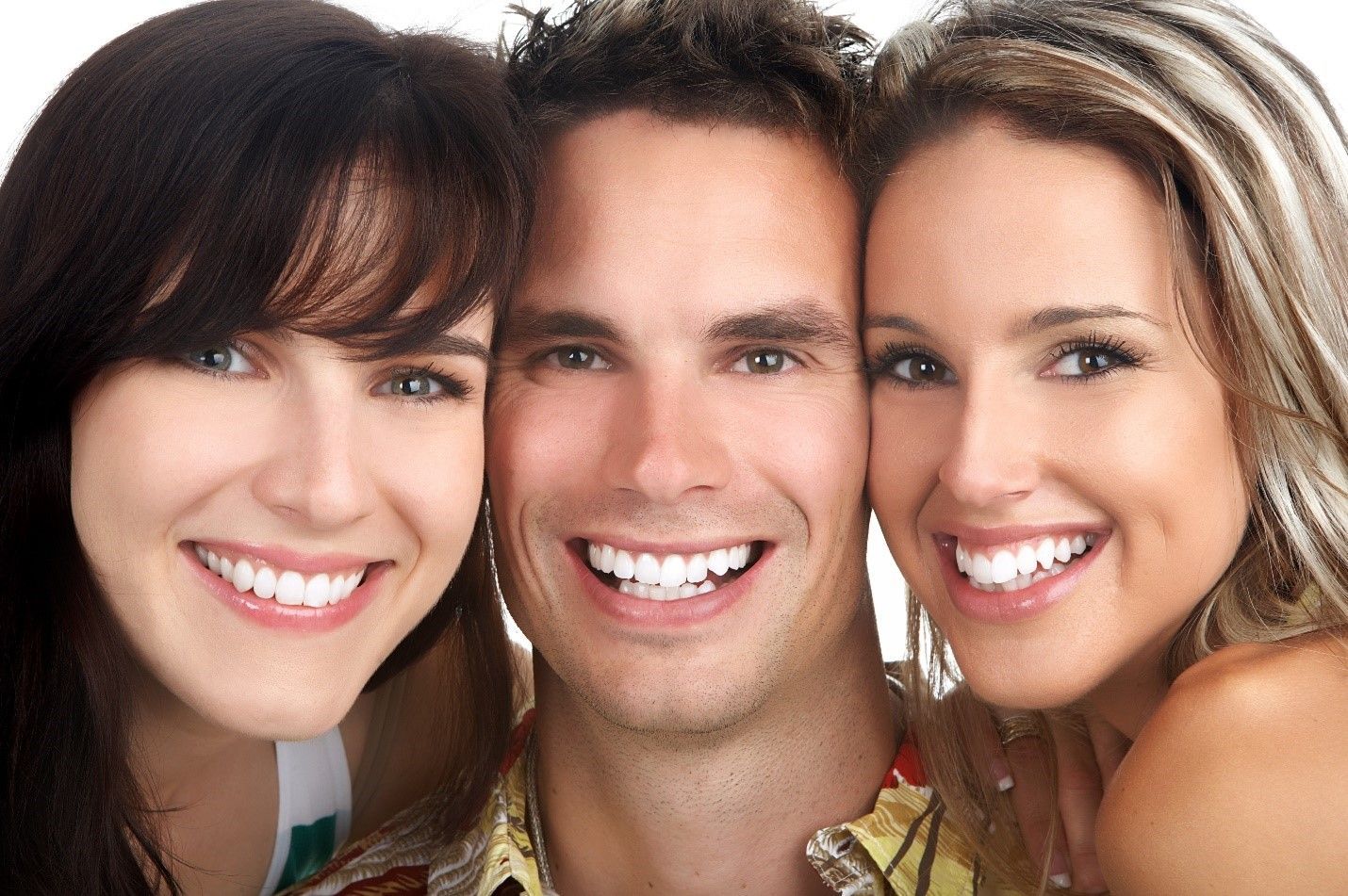 A man and two women are smiling for the camera