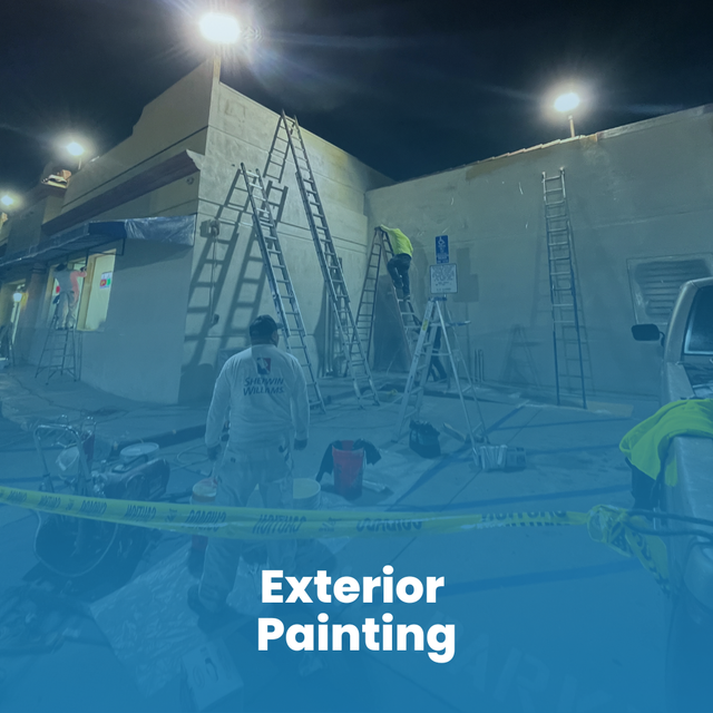 A person on a ladder repairs a hole in a garage ceiling, surrounded by tools and construction materials.