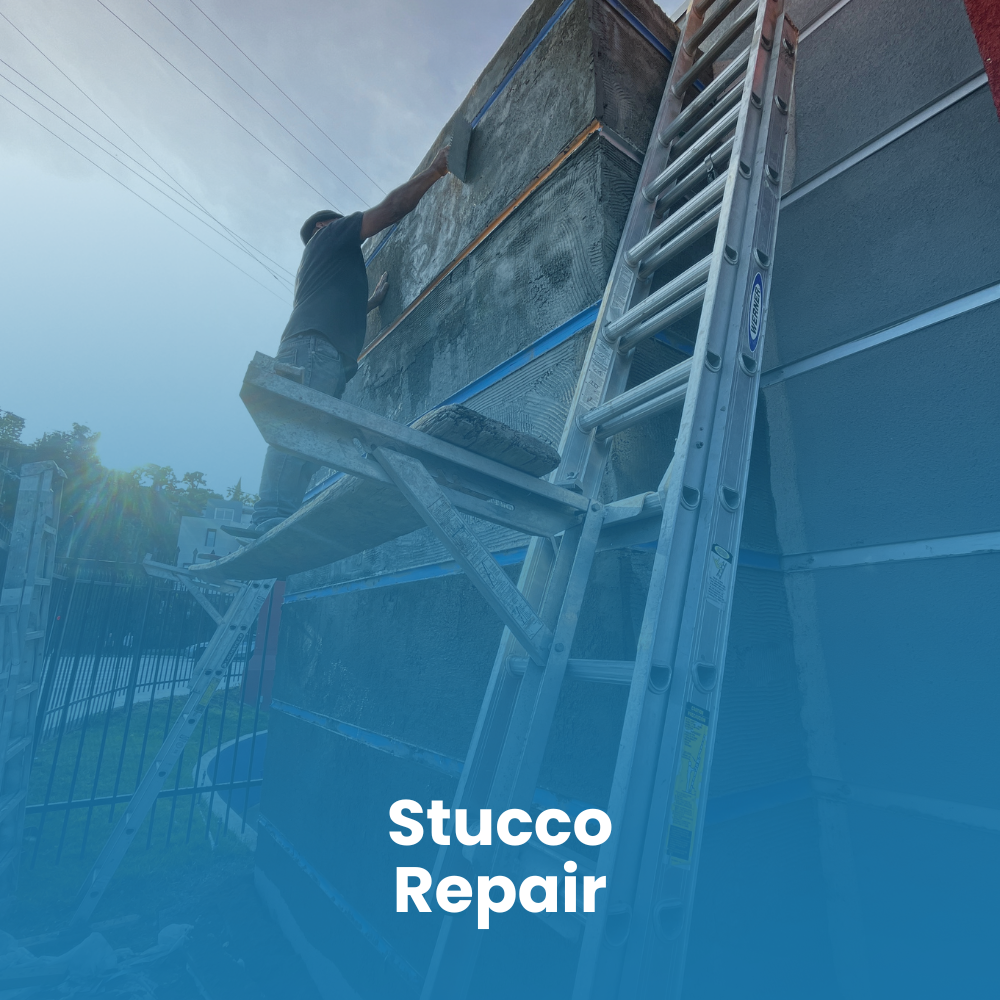 A person on a ladder repairs a hole in a garage ceiling, surrounded by tools and construction materials.