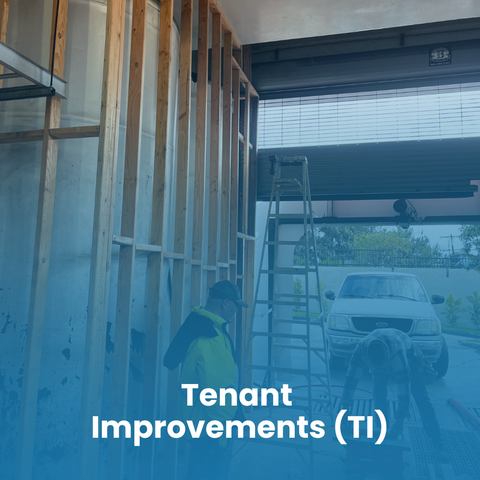 A person on a ladder repairs a hole in a garage ceiling, surrounded by tools and construction materials.