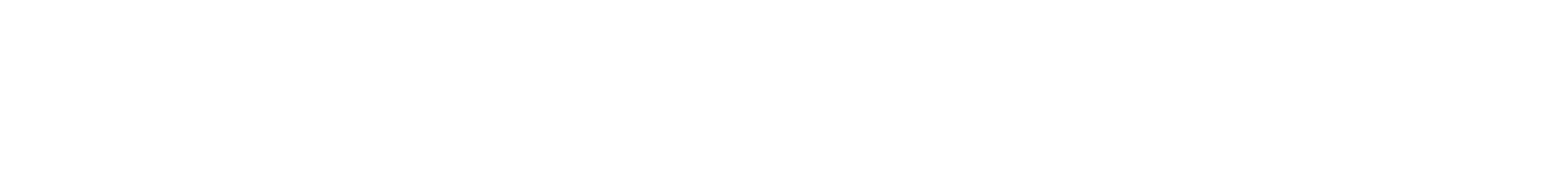 A gold-toned, ornate antique-style mirror with an intricate, decorative frame mounted on a plain white wall.