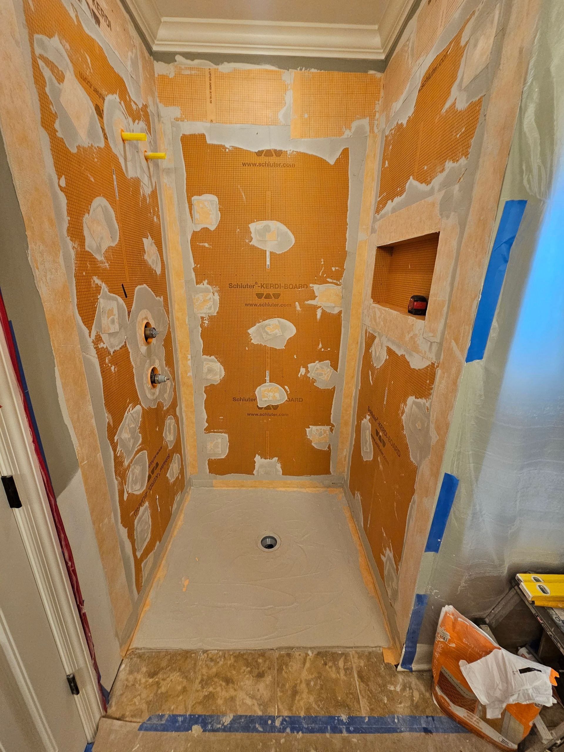 A shower stall is being remodeled in a bathroom.