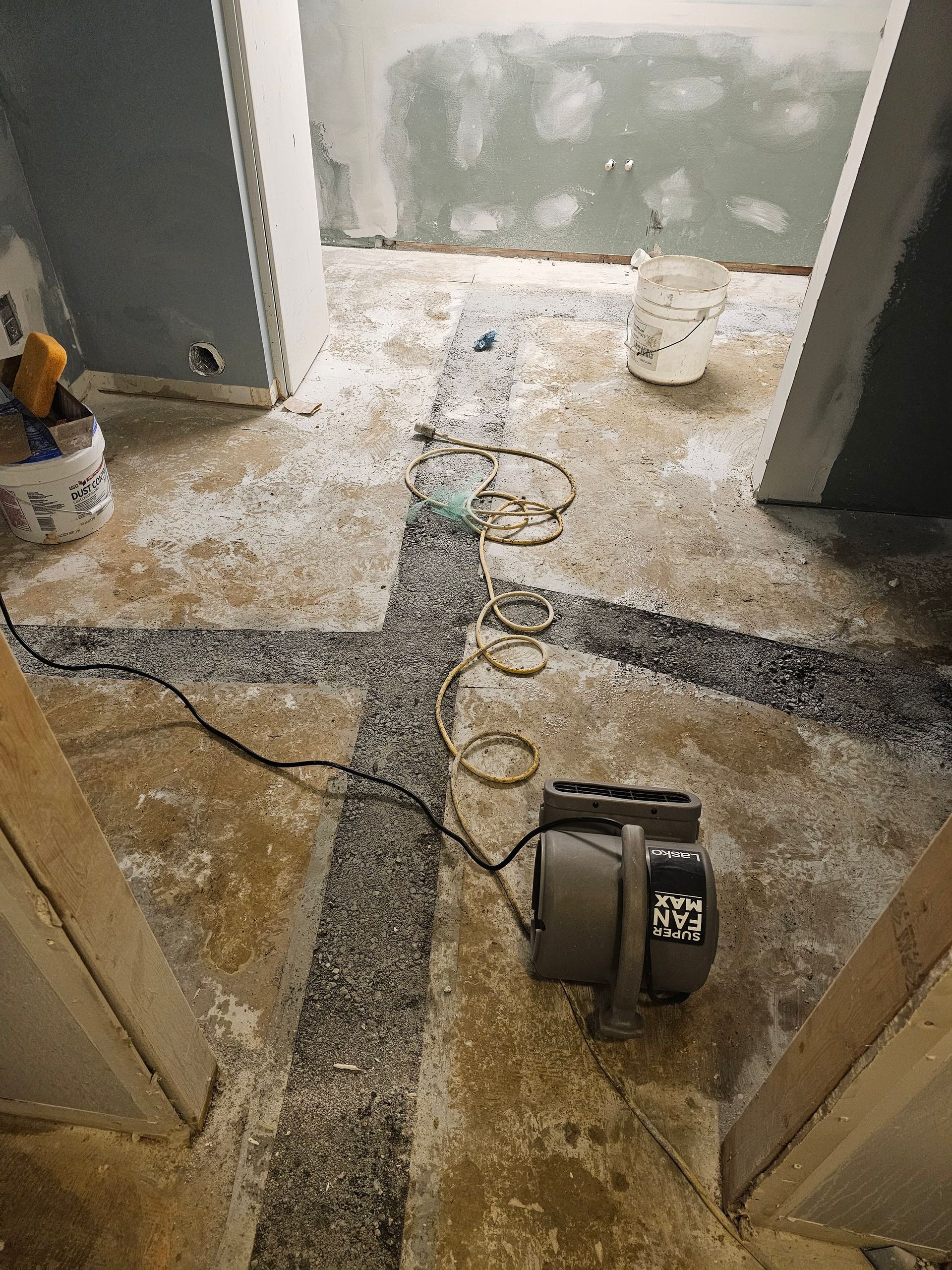 A vacuum cleaner is sitting on the floor of a bathroom under construction.